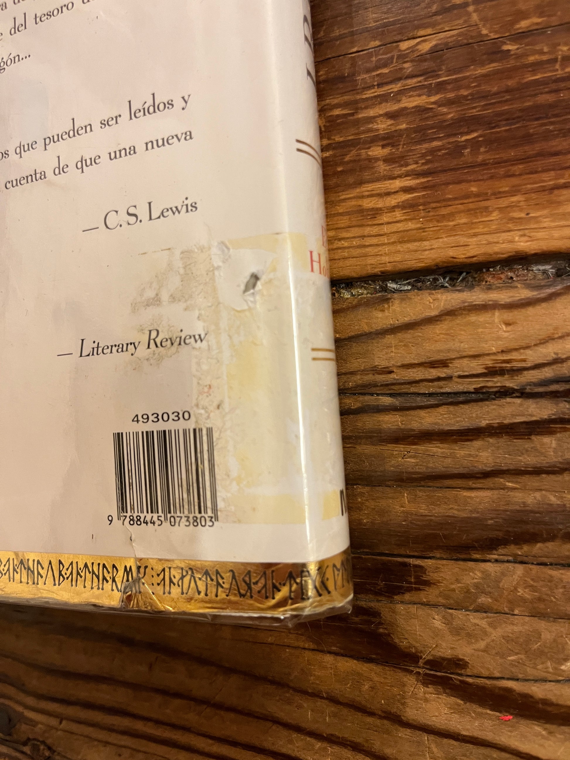 Close-up of a book with a visible barcode and text on a wooden surface