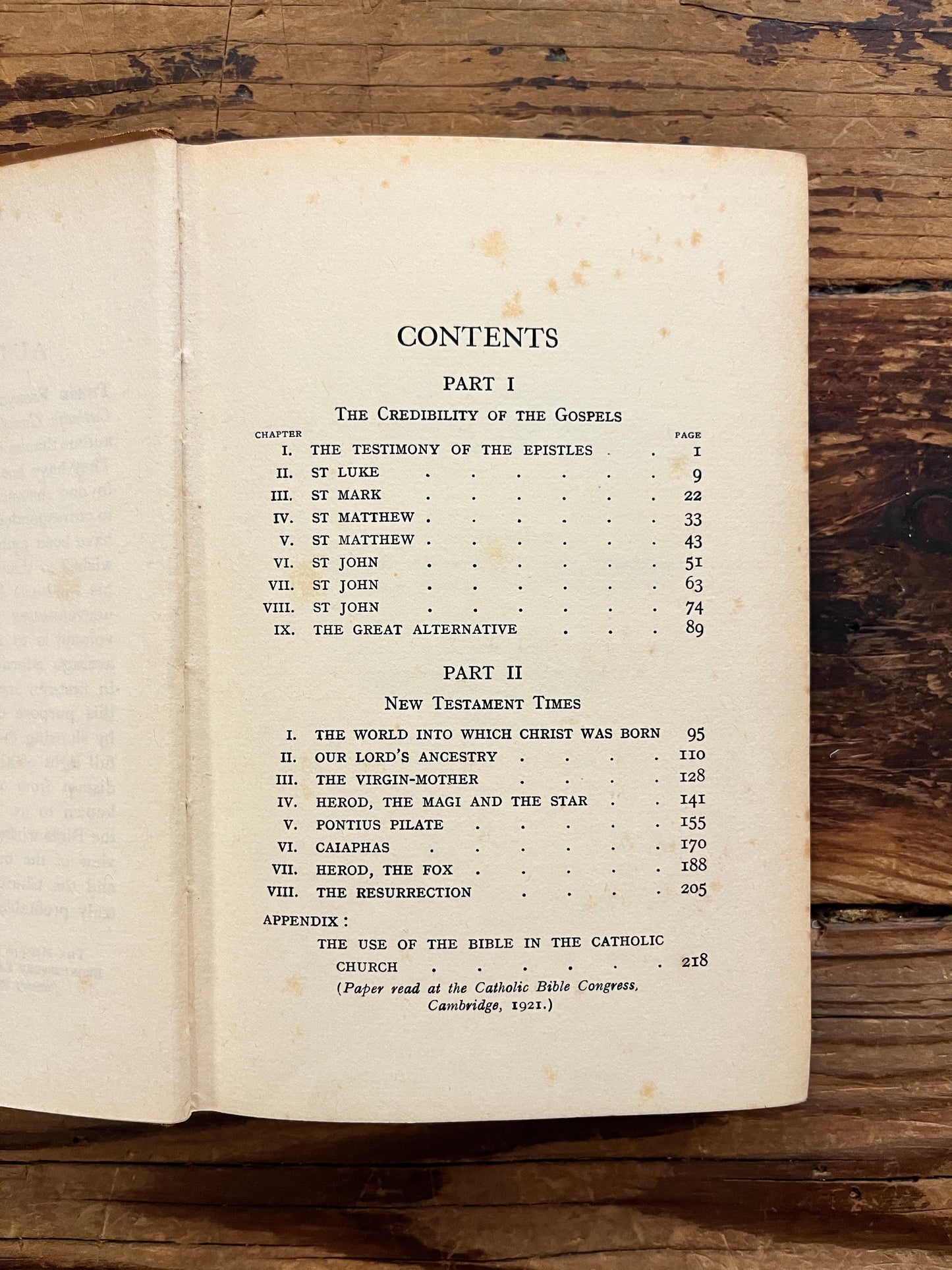 Open book with the title 'the gospels, fact, myth or legend ? by J.P. Arendzen Ph.D. on a wooden surface