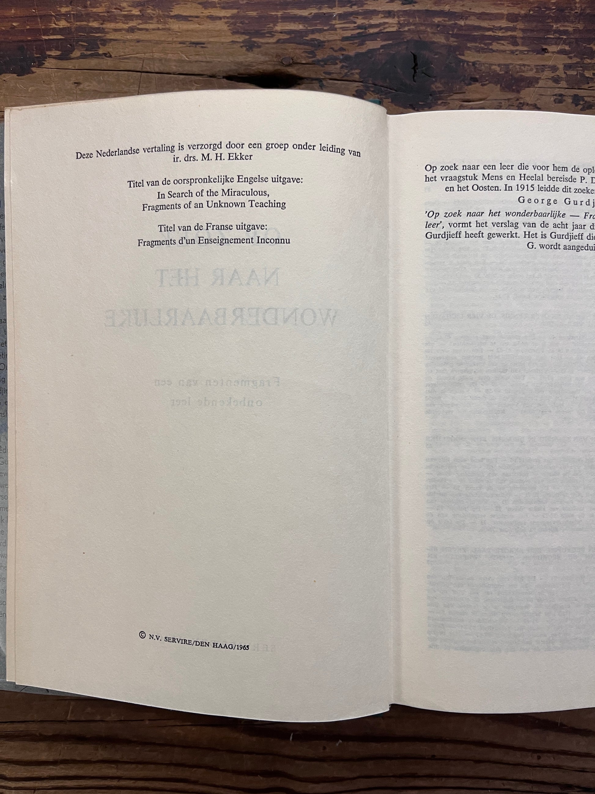 Open boek met de titel 'op zoek naar het wonderbaarlijke, fragmenten van een onbekende leer' door P. D.  Ouspensky op een houten achter grond 