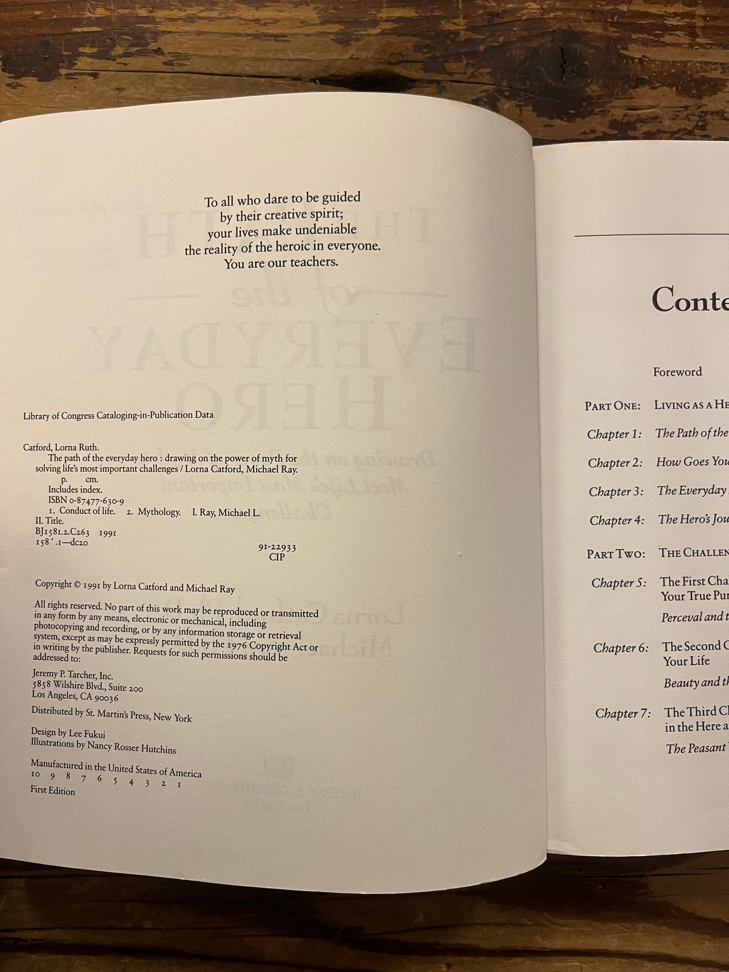 Open book titled 'The Path of the Everyday Hero' on a wooden surface