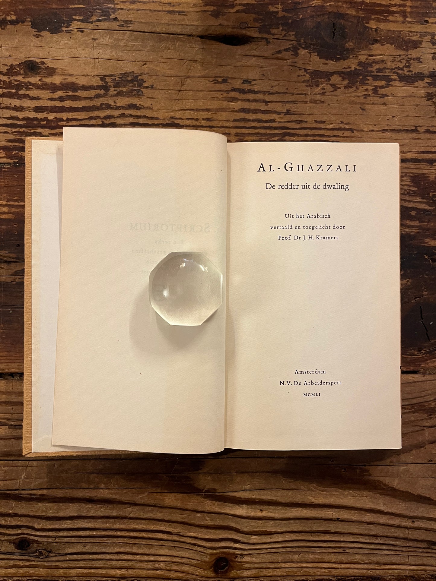 Open Boek met de titel 'de redder uit de dwaling' door Al-Ghazzali op een houten achtergrond 