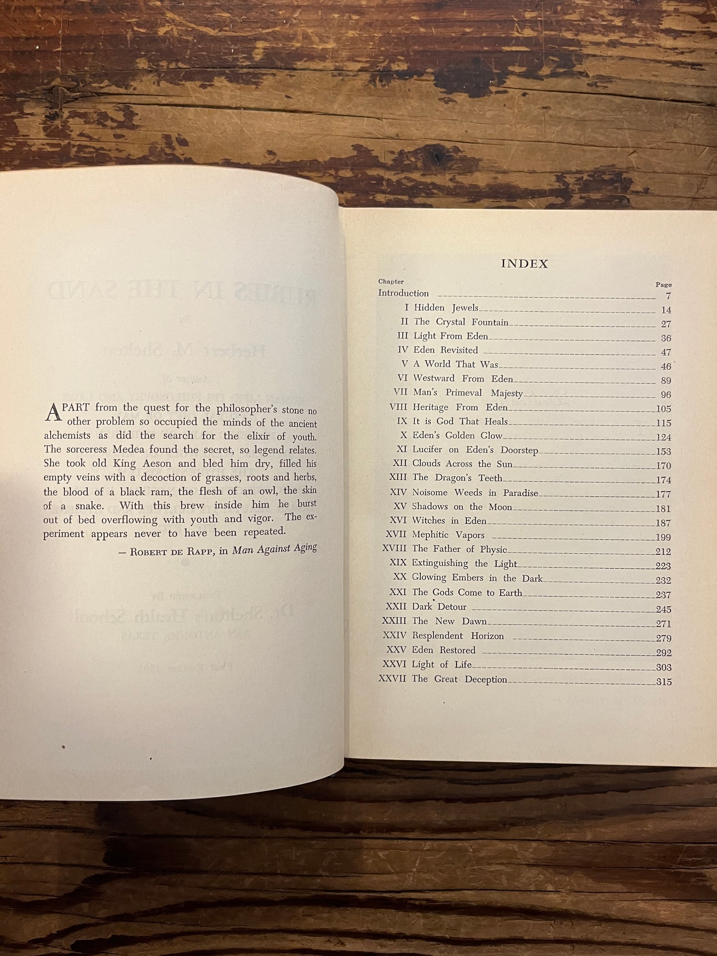 Open book titled 'Rubies in the Sand' by Herbert M. Shelton on a wooden surface