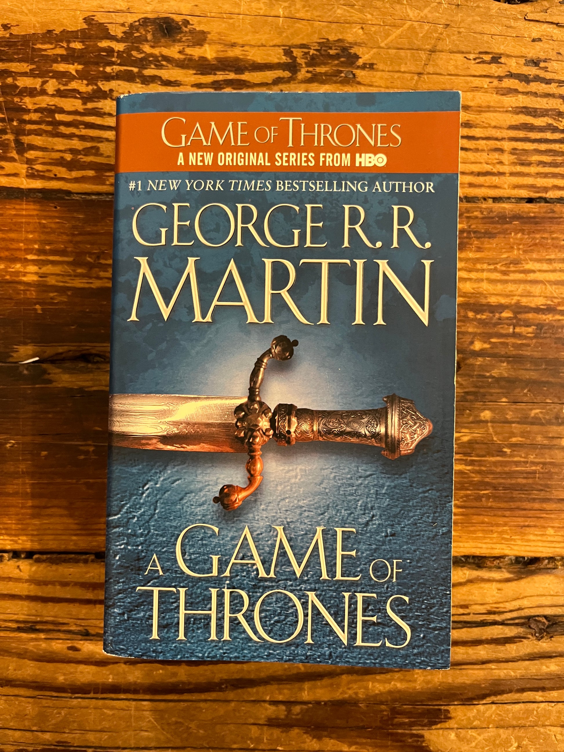 Book titled 'A Game of Thrones' by George R.R. Martin on a wooden surface