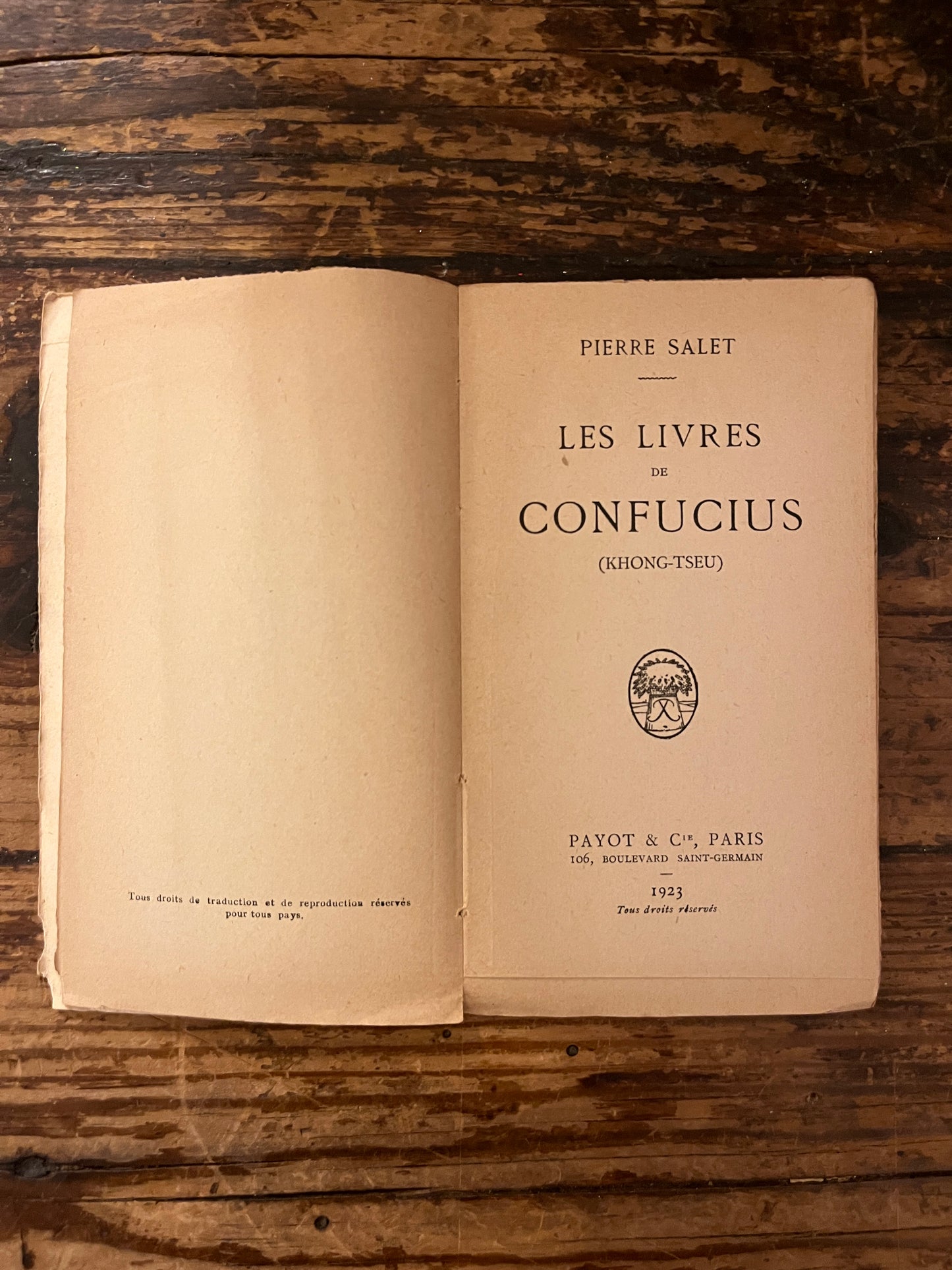 page de titre du livre " les livres de confucius" sur fond de bois