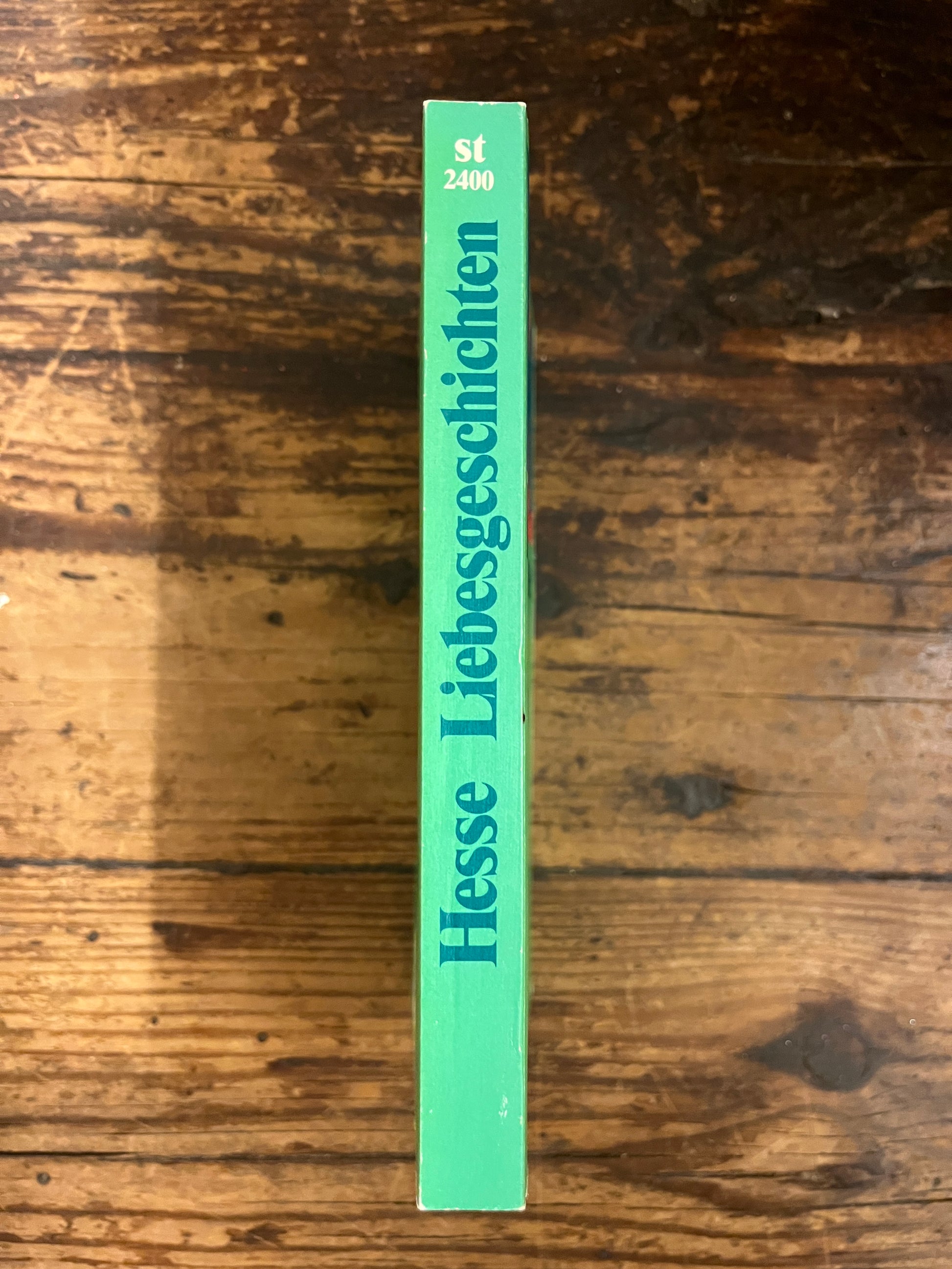 photo of the spine of the book "Liebesheschichten" on a wooden background