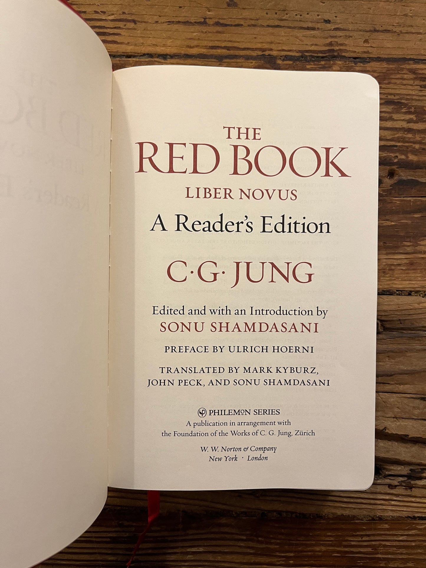 Open book titled 'The Red Book' by C.G. Jung on a wooden surface
