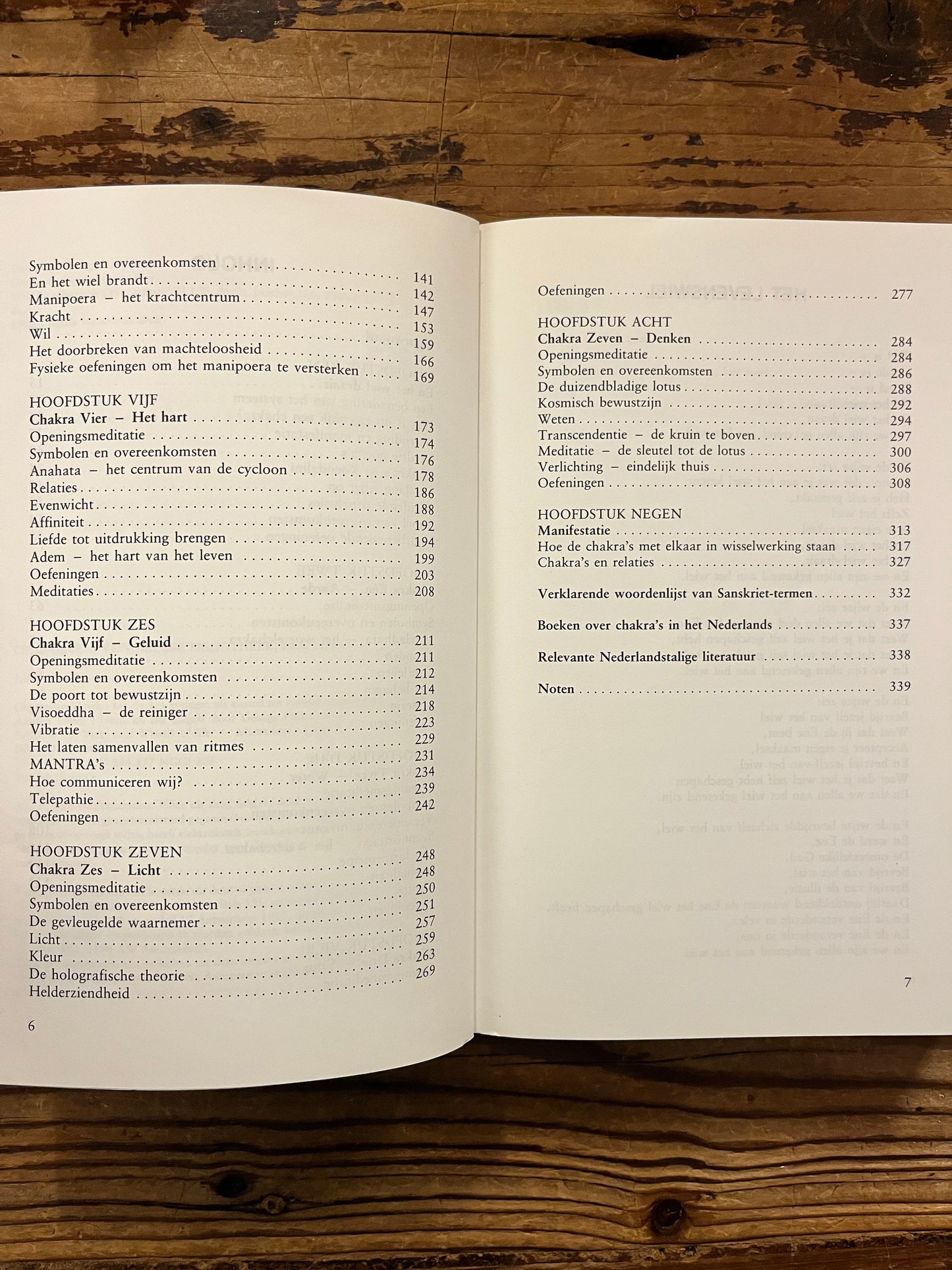 Open boek met de titel 'Chakra werkboek' door Andrea Judith op een houten achtergrond 