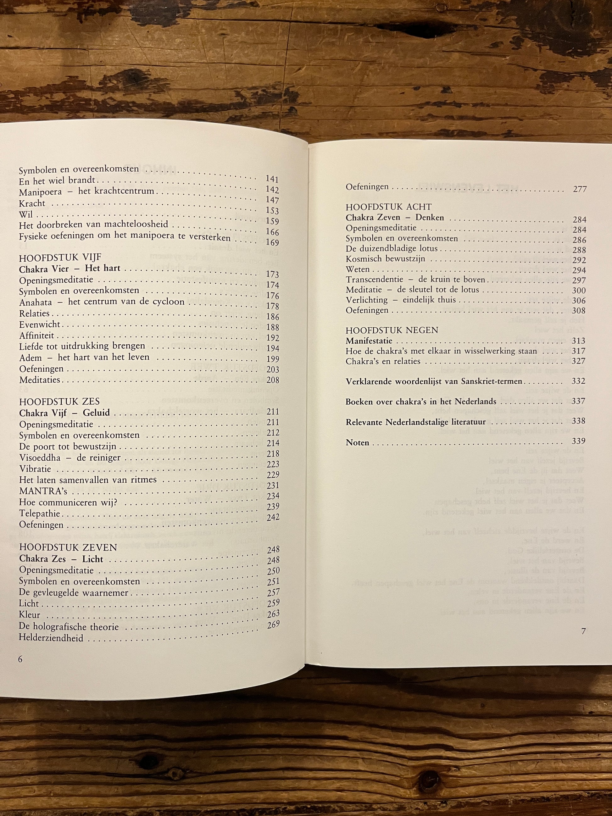 Open boek met de titel 'Chakra werkboek' door Andrea Judith op een houten achtergrond 