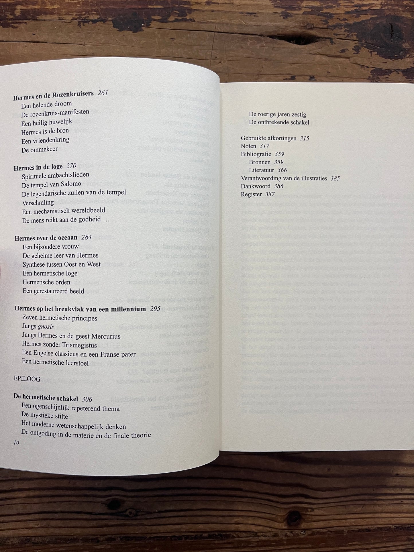 Open boek met de titel 'de Hermetische Schakel' door Jacob Slavenburg op een houten achtergrond 