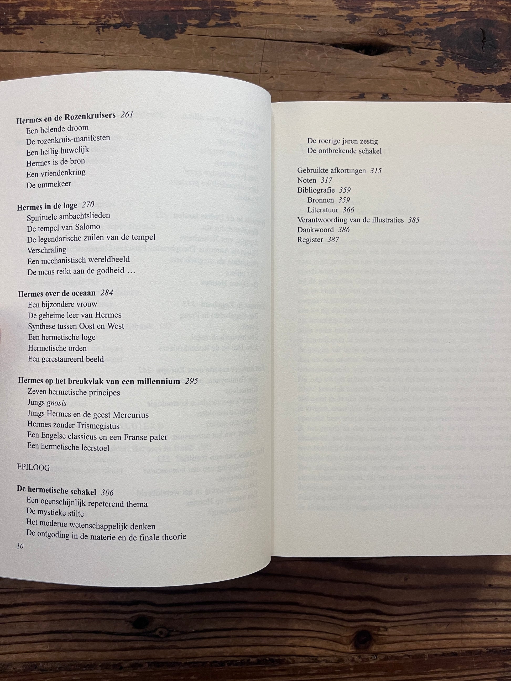 Open boek met de titel 'de Hermetische Schakel' door Jacob Slavenburg op een houten achtergrond 