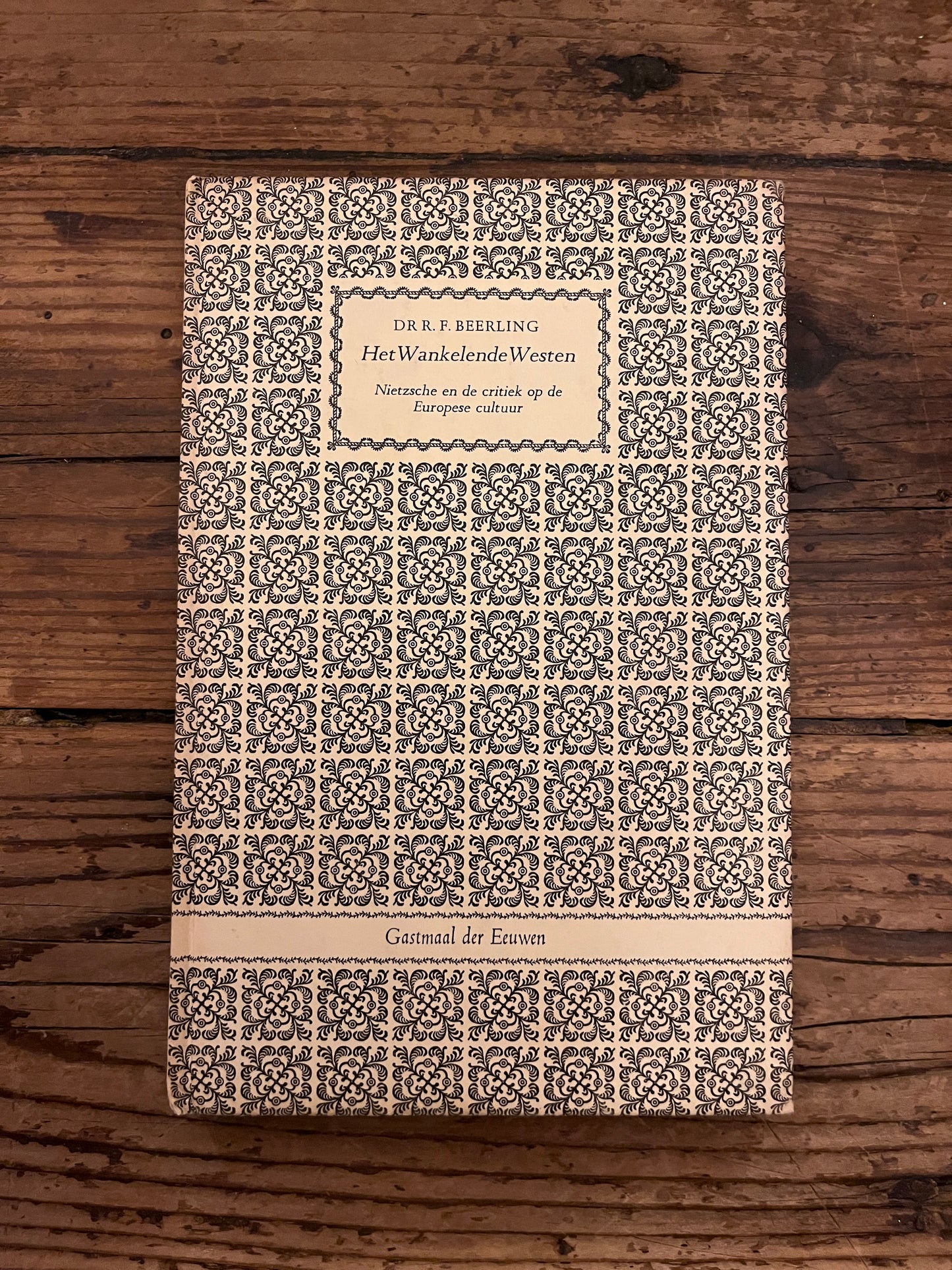 foto van de cover van het boek "het wankelende westen" op een houten achtergrond