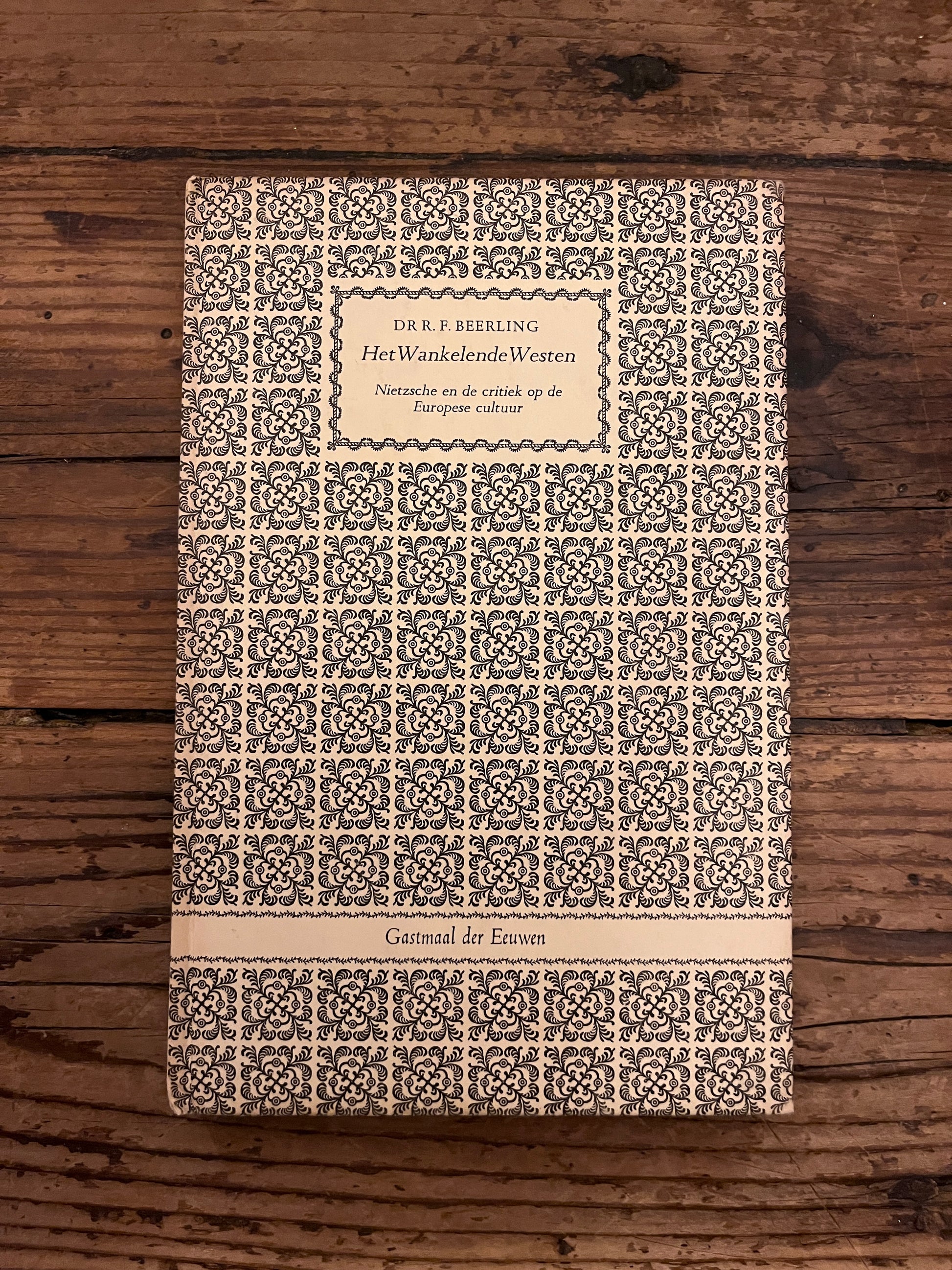 foto van de cover van het boek "het wankelende westen" op een houten achtergrond