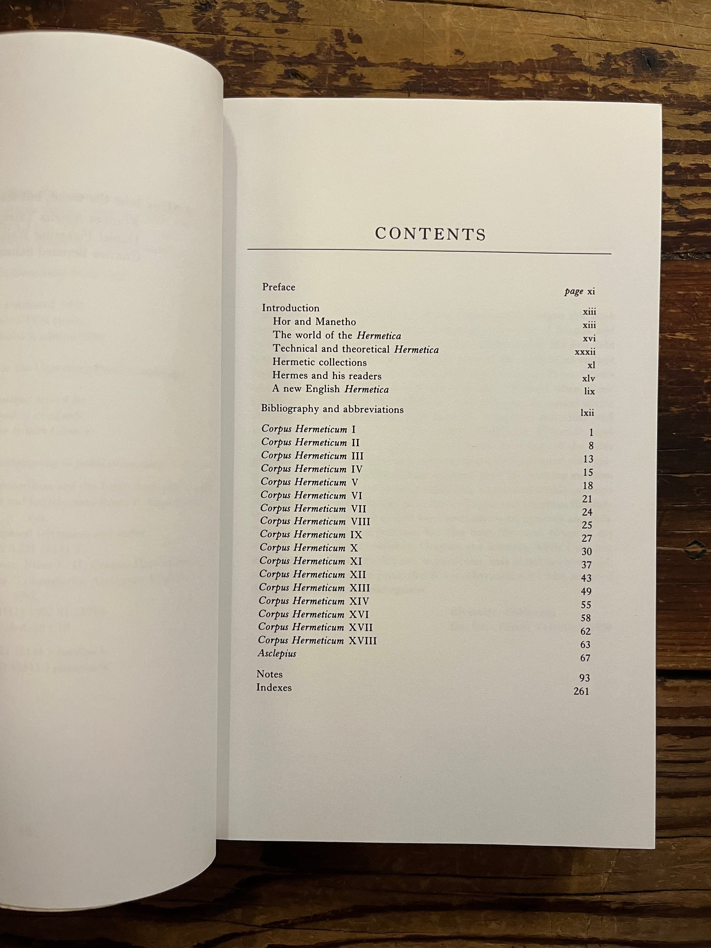 Open book with the title 'Hermetica' door Brian P. Copenhaver on a wooden surface