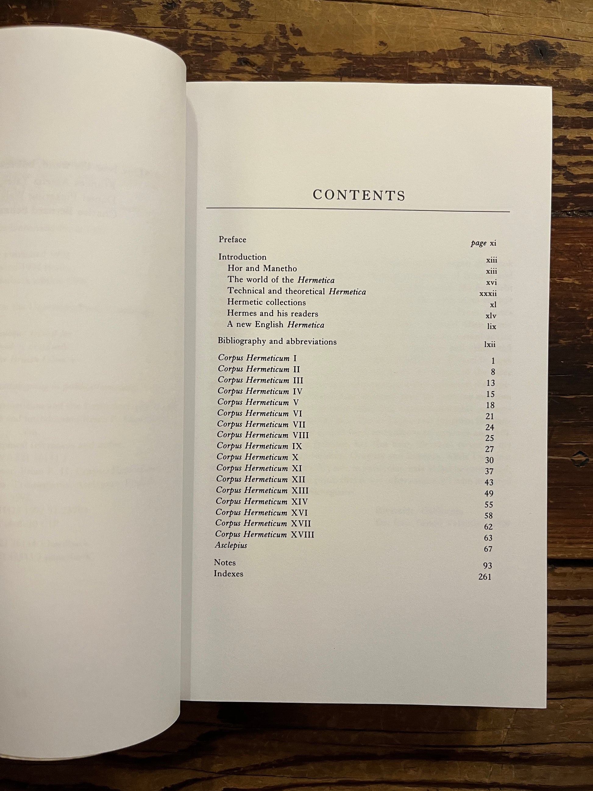 Open book with the title 'Hermetica' door Brian P. Copenhaver on a wooden surface