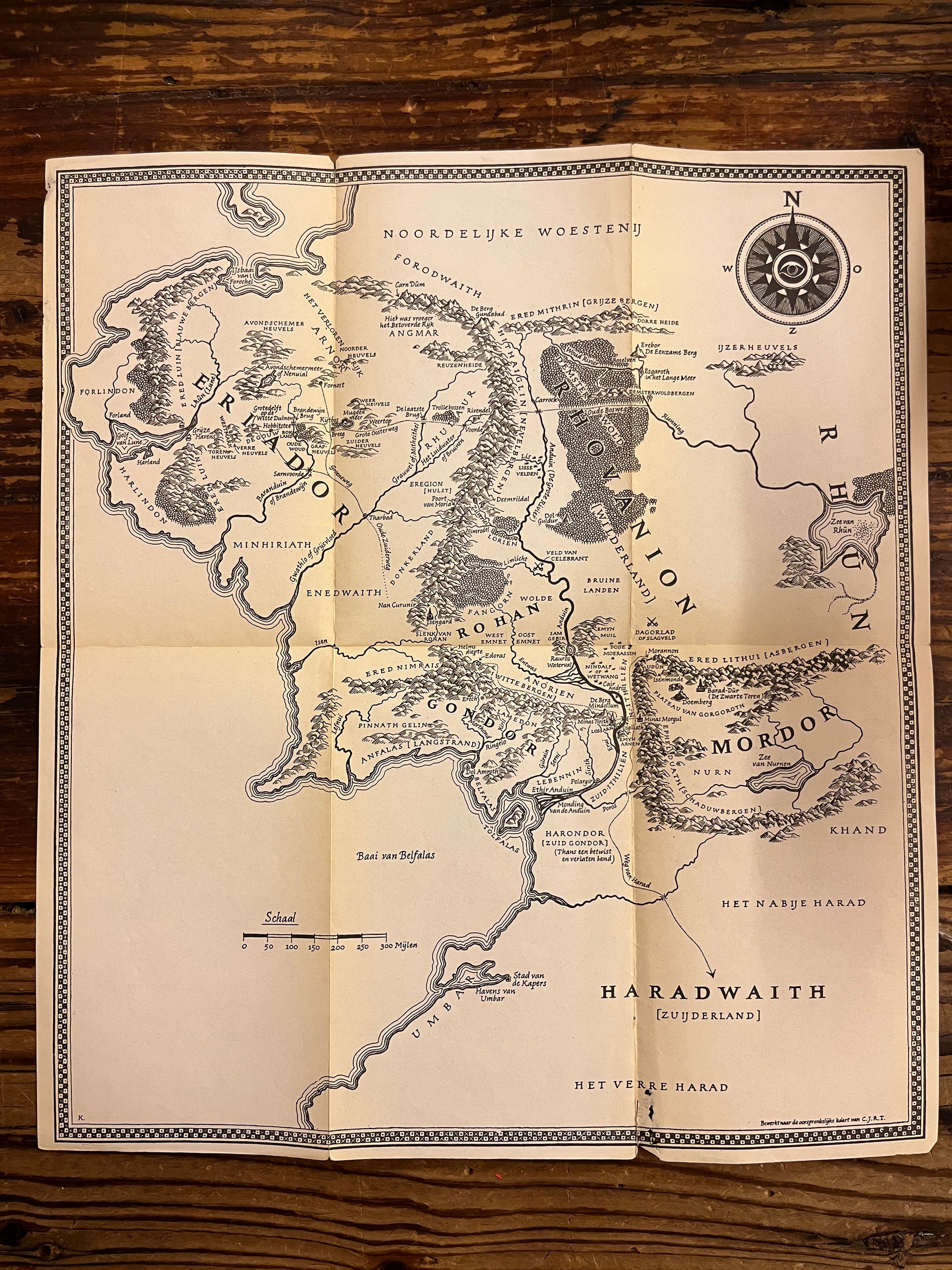 losse map van 'in de ban van de ring' die bij de set van boeken komt, op een houten achtergrond 