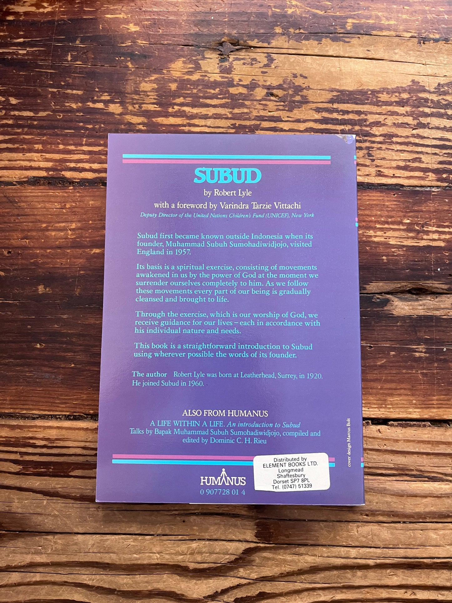 Back cover of book with the title 'Subud' by Robert Lyle on a wooden surface 