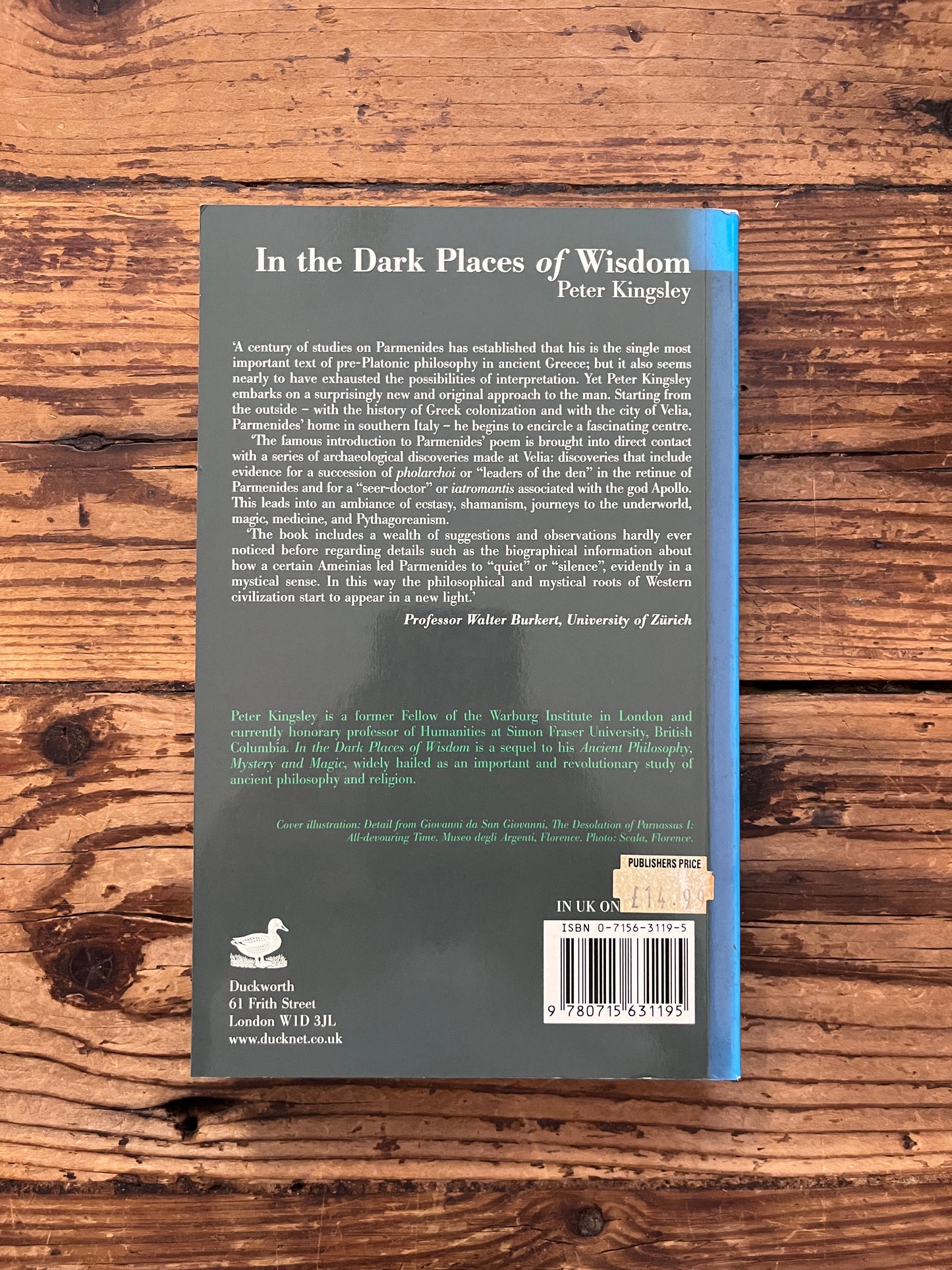 photo of the cover of the book "the dark places of wisdom" on a wooden background