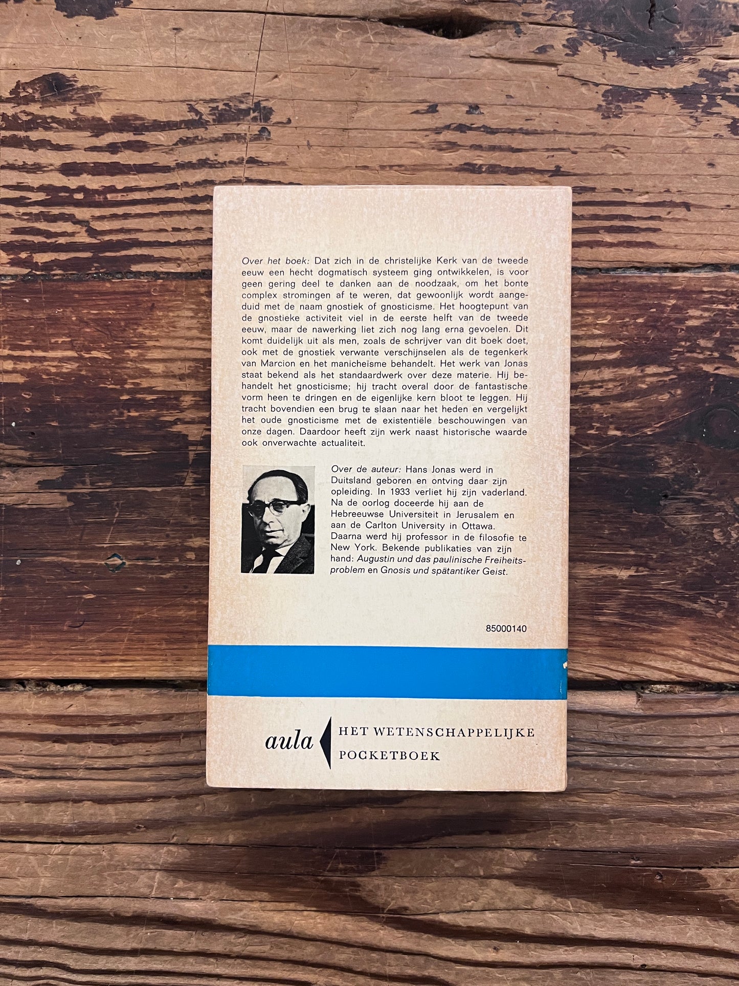 Achterkant van boek met de titel 'Het Gnosticisme' door Hans Jonas op een houten achtergrond 