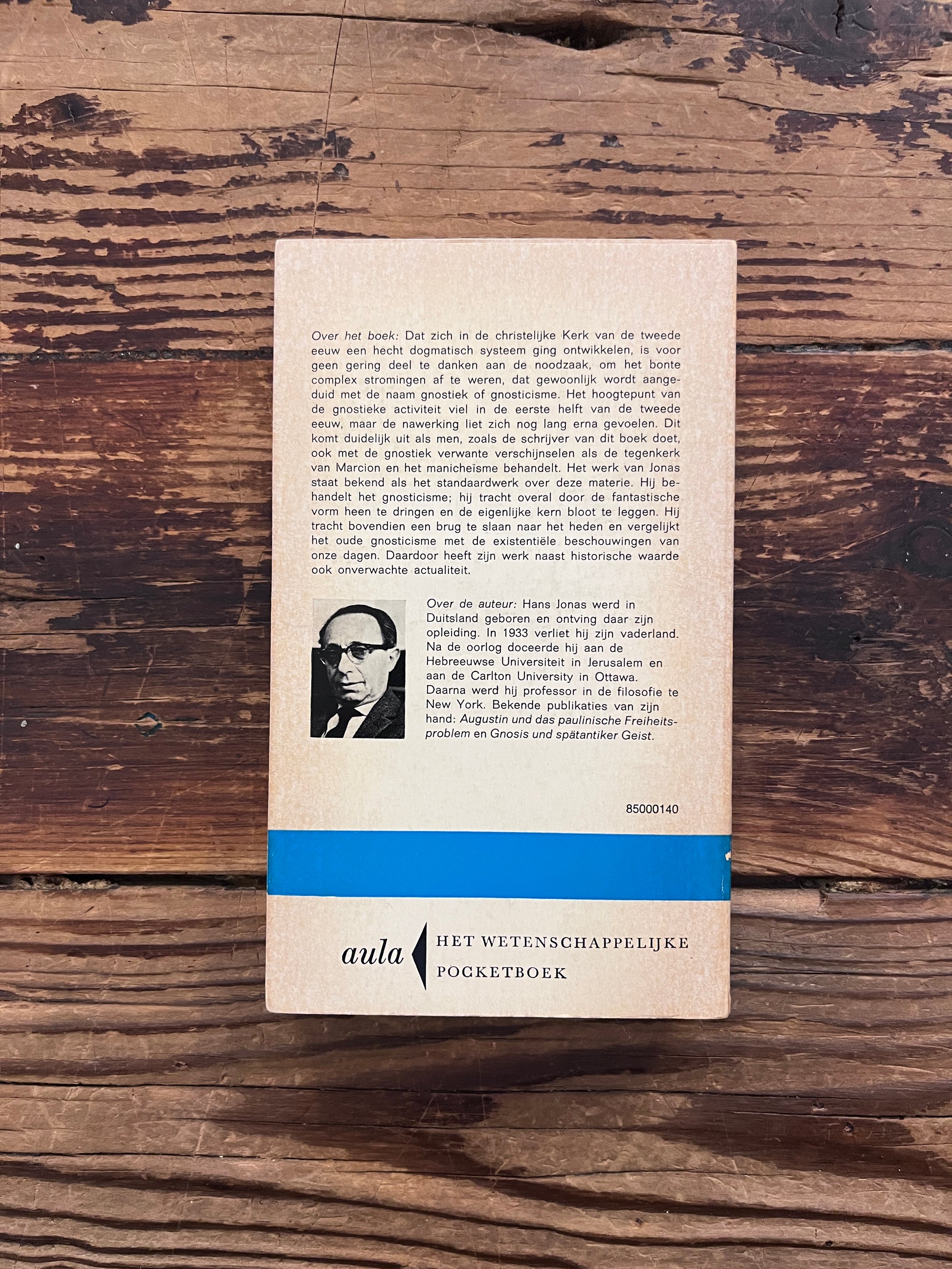 Achterkant van boek met de titel 'Het Gnosticisme' door Hans Jonas op een houten achtergrond 