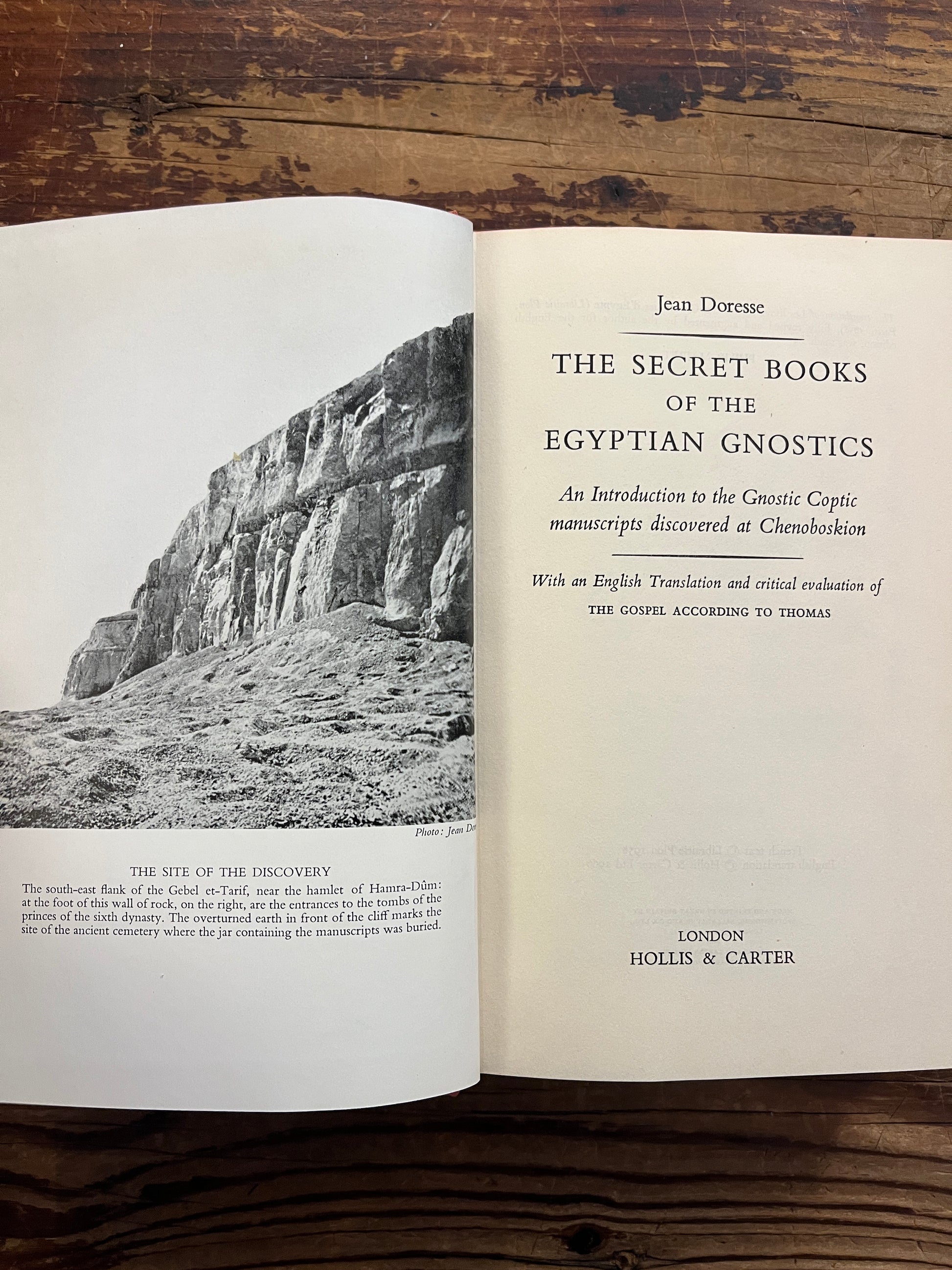 Open book titled 'The Secret Books of the Egyptian Gnostics' by Jean Doresse on a wooden surface