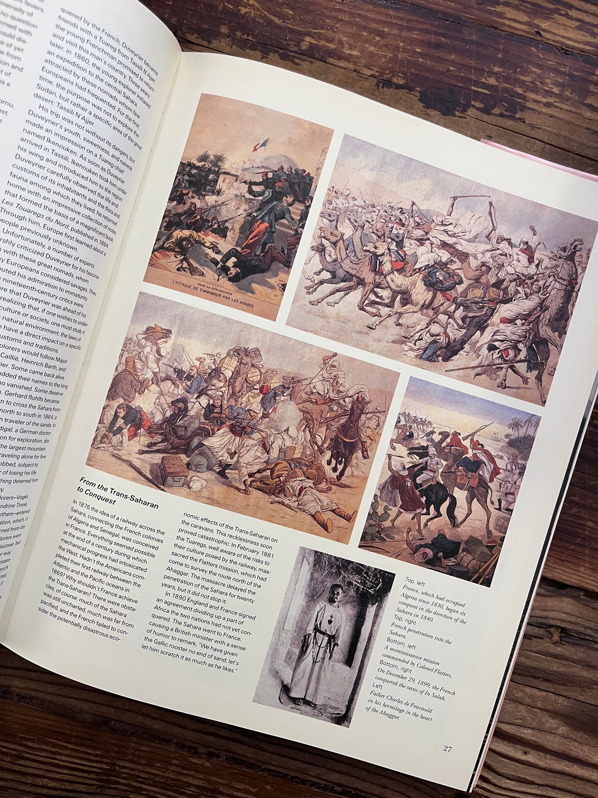 Open book titled 'Sahara: The Forbidding Sands' by Jean-Marc Durou on a wooden surface
