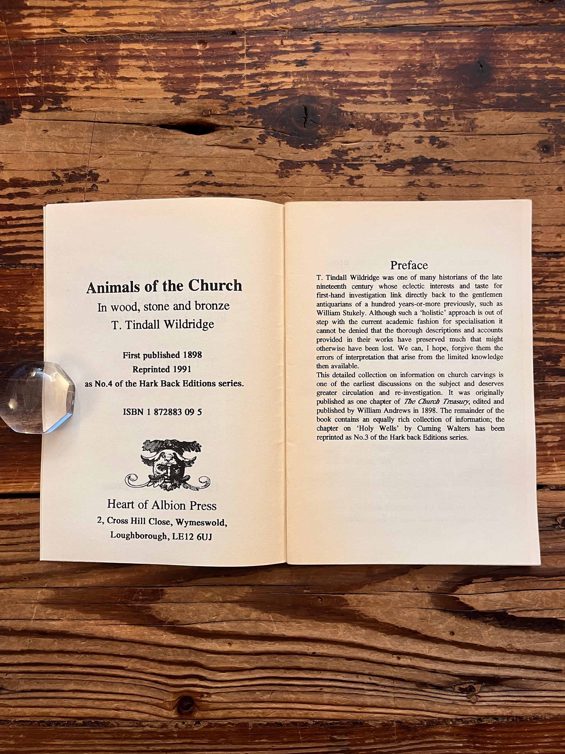 Open booklet with the title 'Animals of the chruch' by T. Tindall Wildridge on a ooden surface 