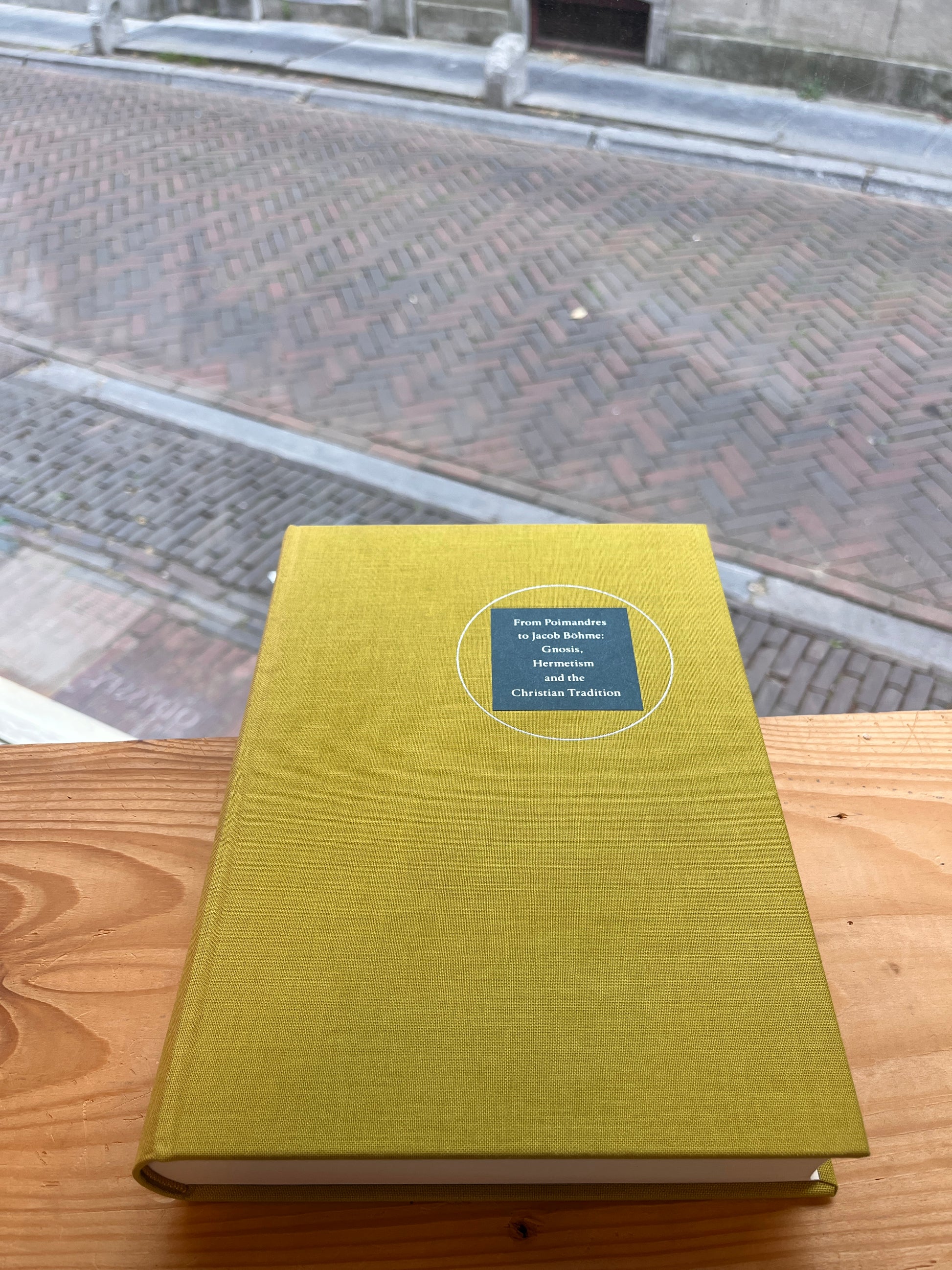 Front cover of book titled 'From Poimandres to Jacob Böhme: Gnosis, Hermetism, and the Christian tradition Edited by Roelof van den Broek and Cis van Heertum' in front of a window 