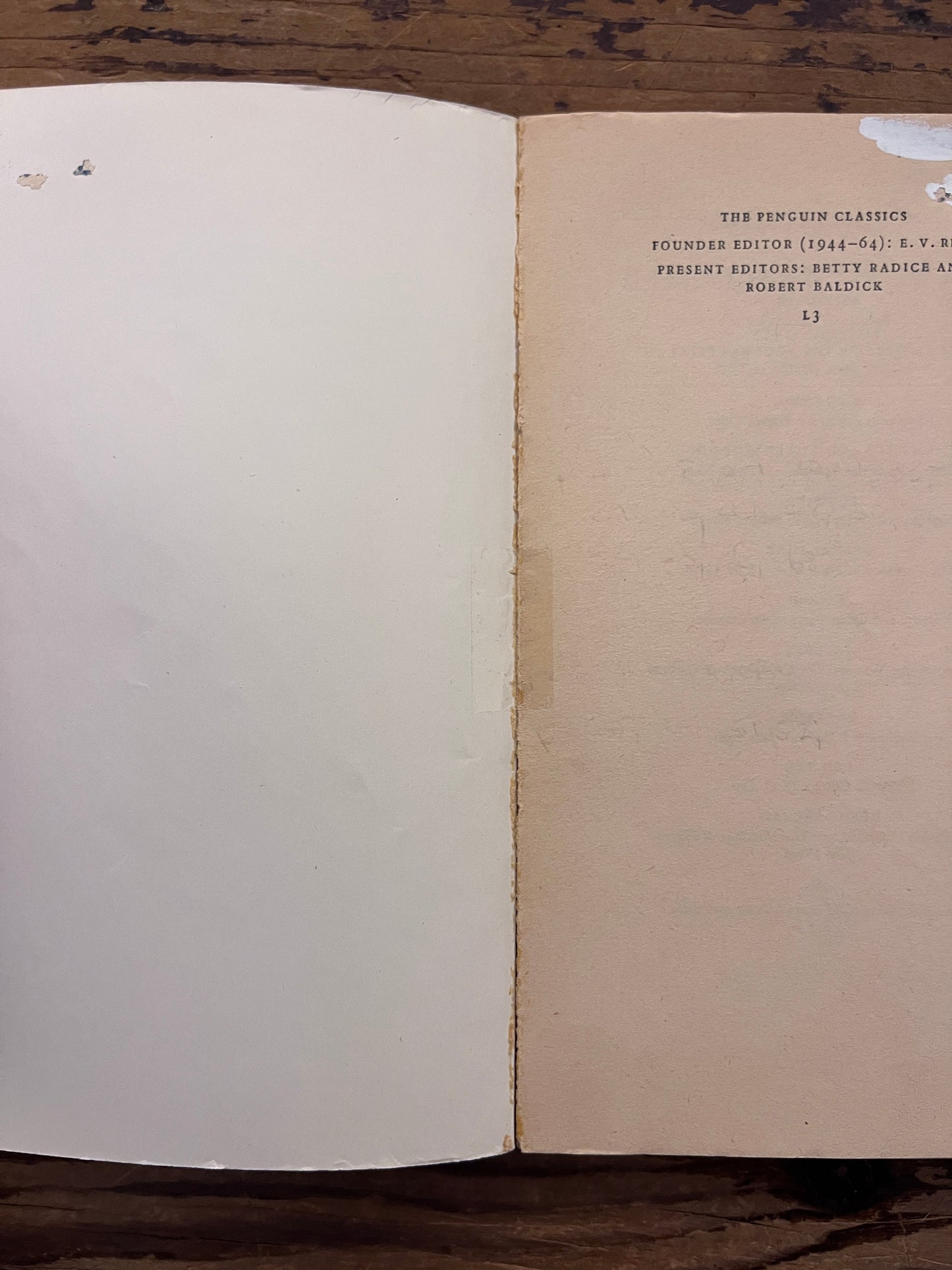 Open book titled 'the theban plays' by Sophocles on a wooden surface