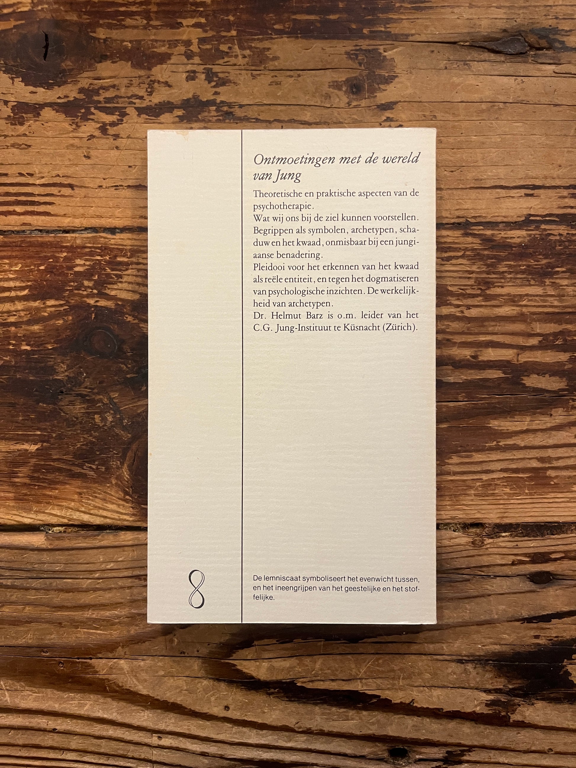 Boek met de titel 'Over de ziel, hoofdpunten in de jungiaanse psychotherapie' door H. Barz op een houten achtergrond 