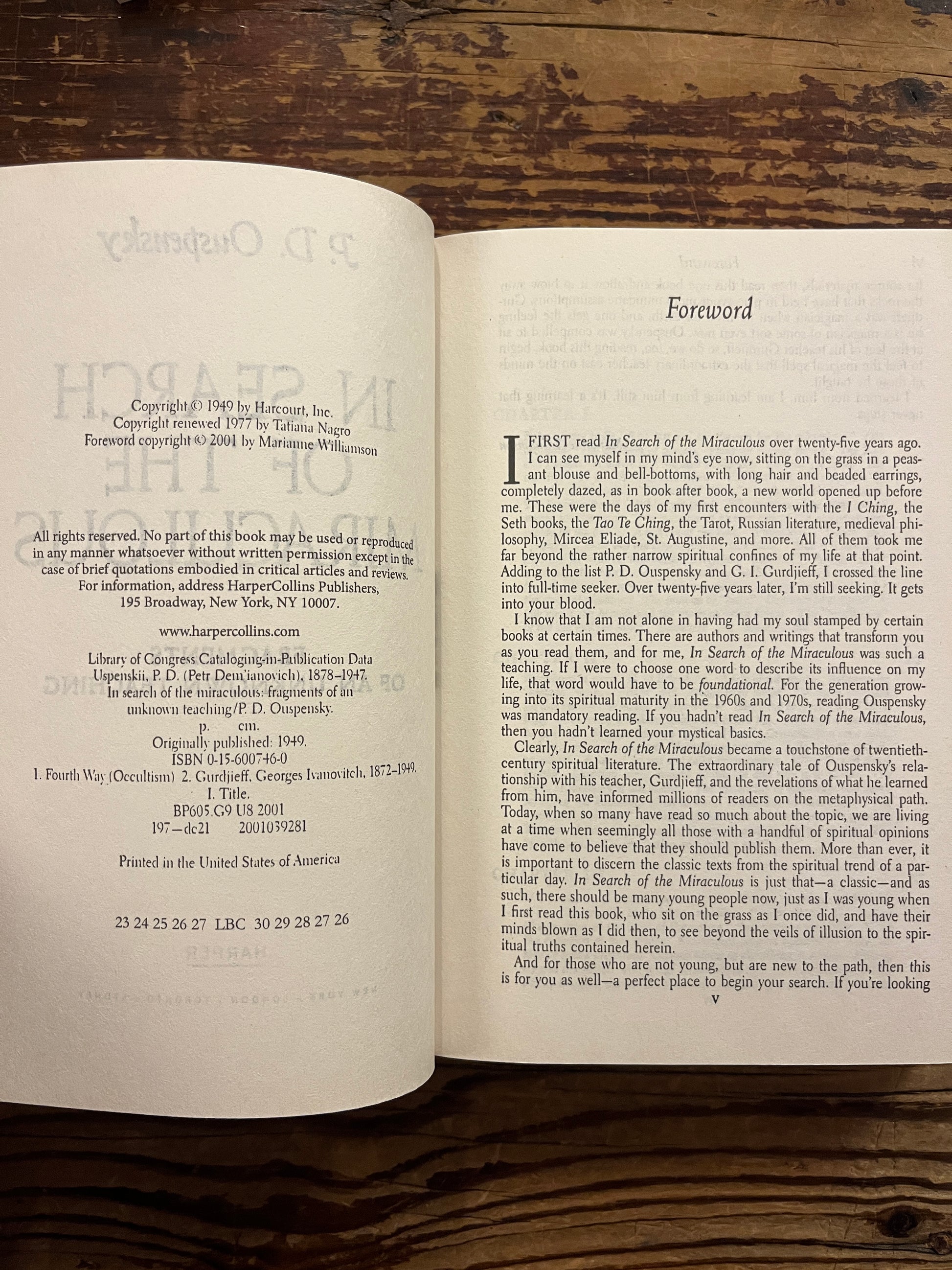 Open book titled 'In Search of the Miraculous' by P.D. Ouspensky on a wooden surface