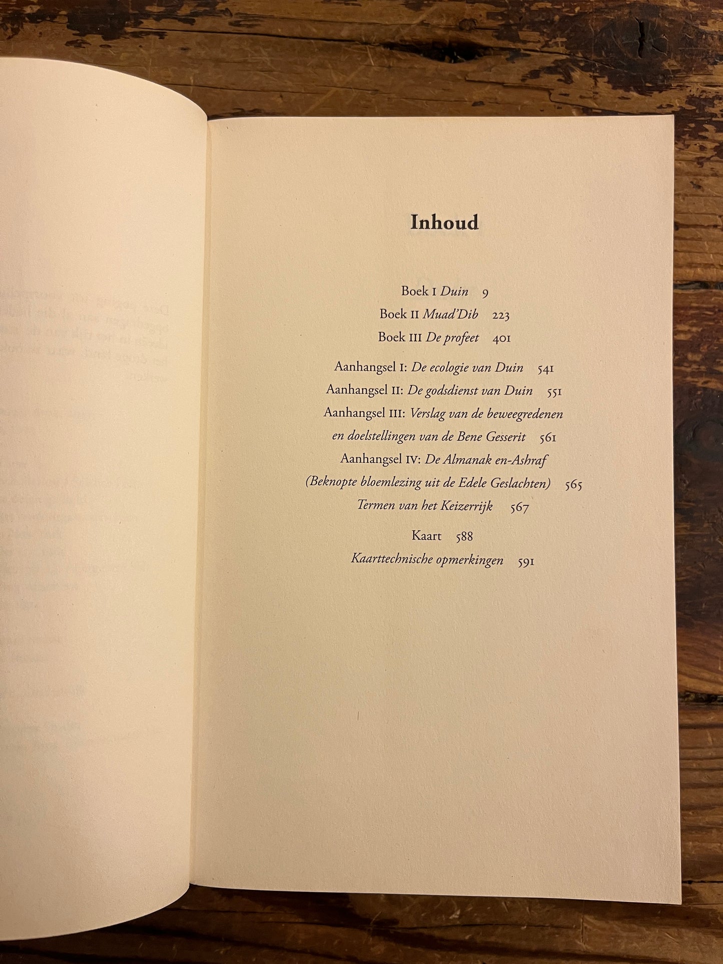 Open boek met de titel 'Dune' door Frank Herbert op een houten achtergrond