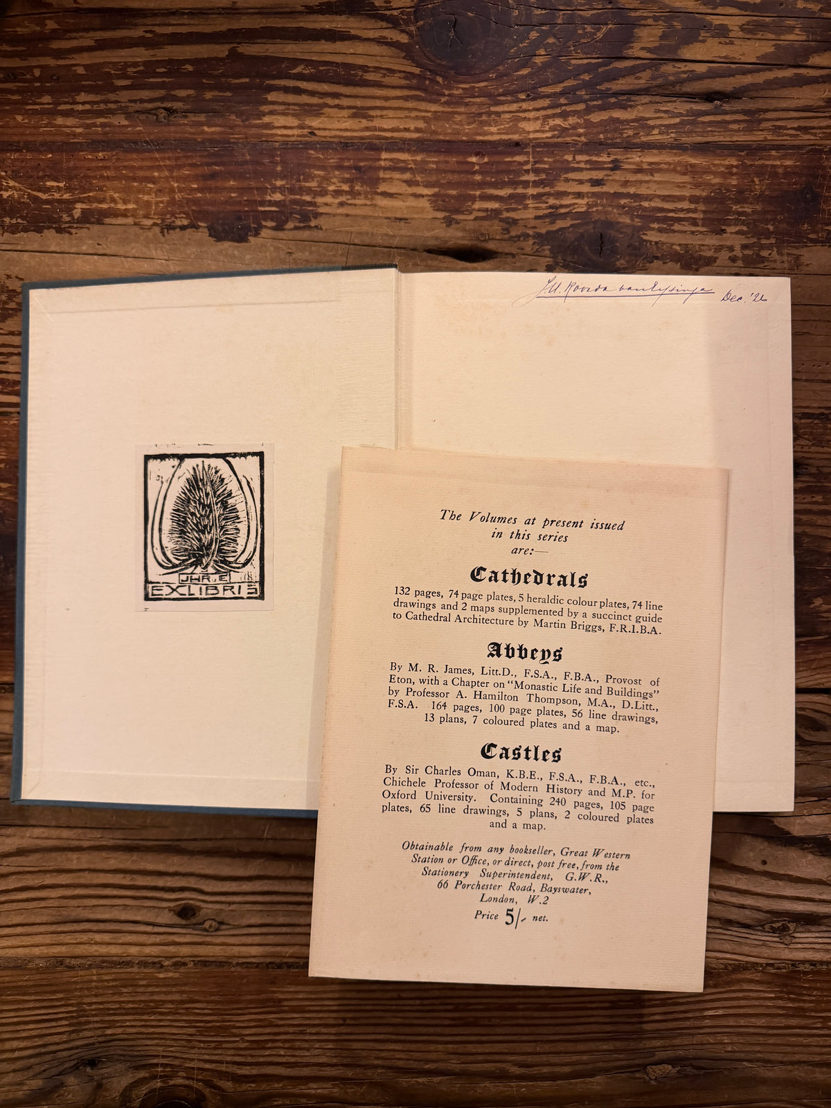 Open book titled 'Cathedrals' from 1926 from the series made by 'The Great Western Railway' and the additional ephemera exposed on a wooden surface