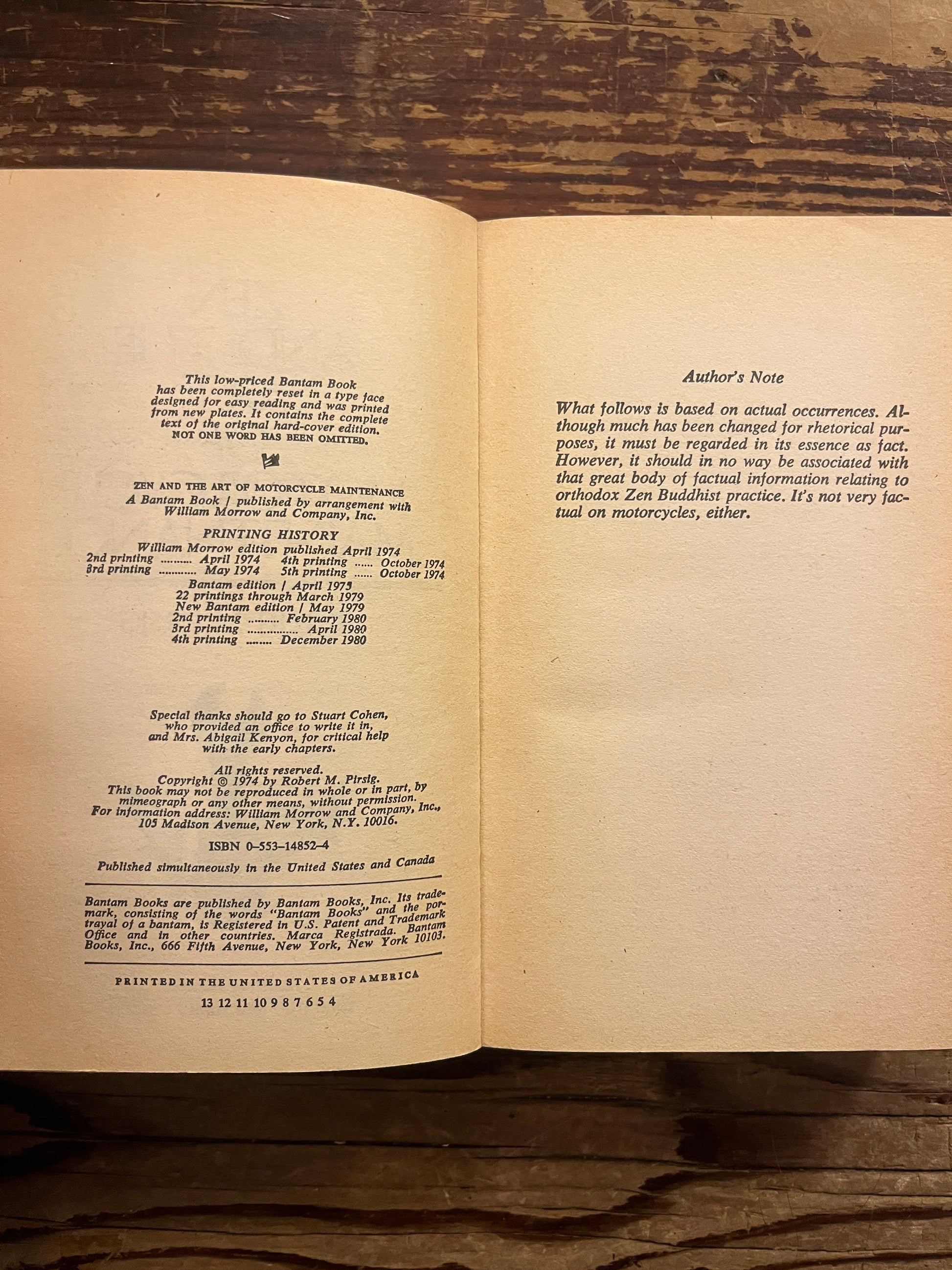 Open Book titled 'Zen and the Art of Motorcycle maintenance' by Robert M. Persig on a wooden surface