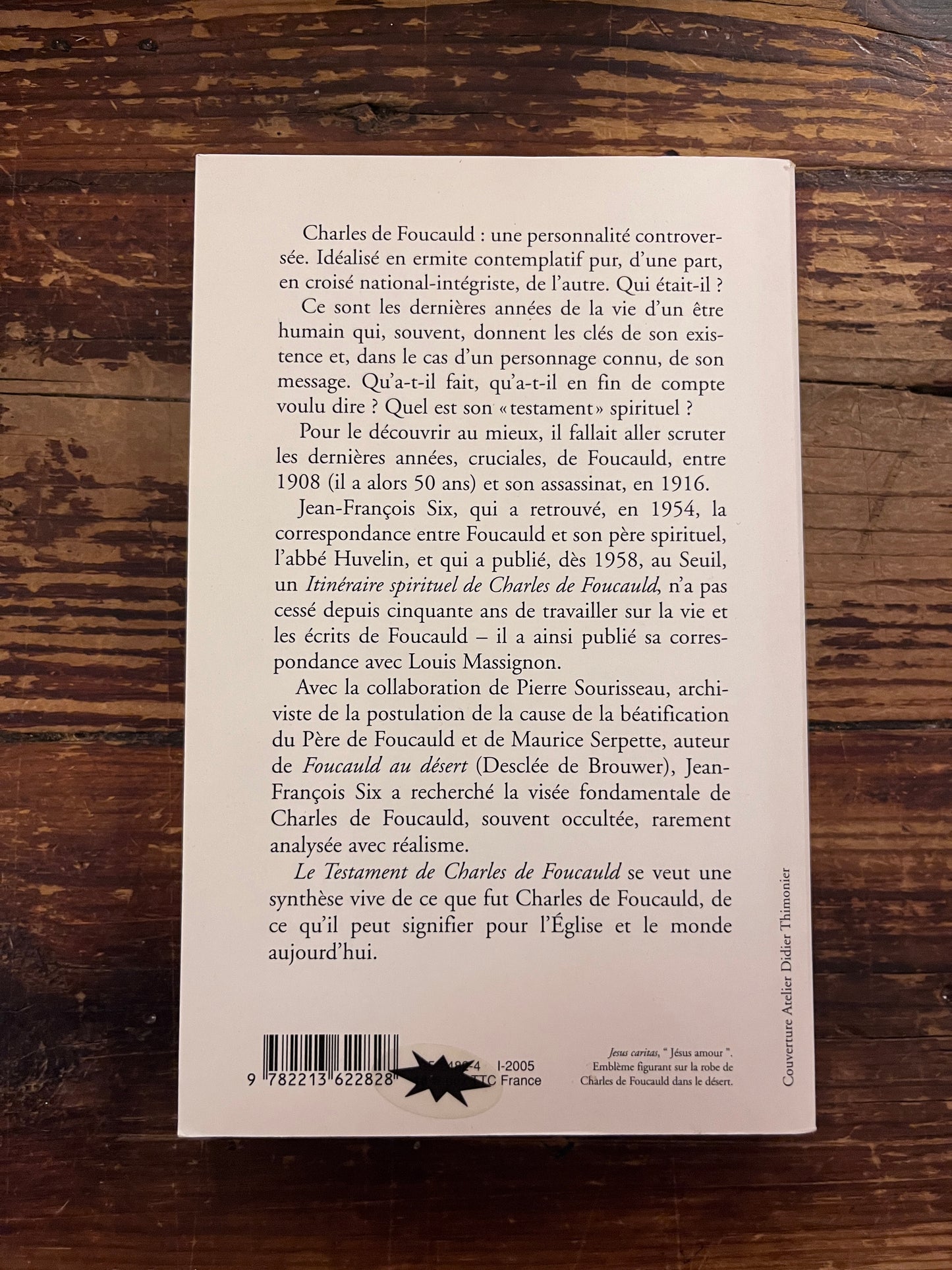 photo de la quatrieme de couverture du livre "le testament de charles de foucauld"sur fond de bois