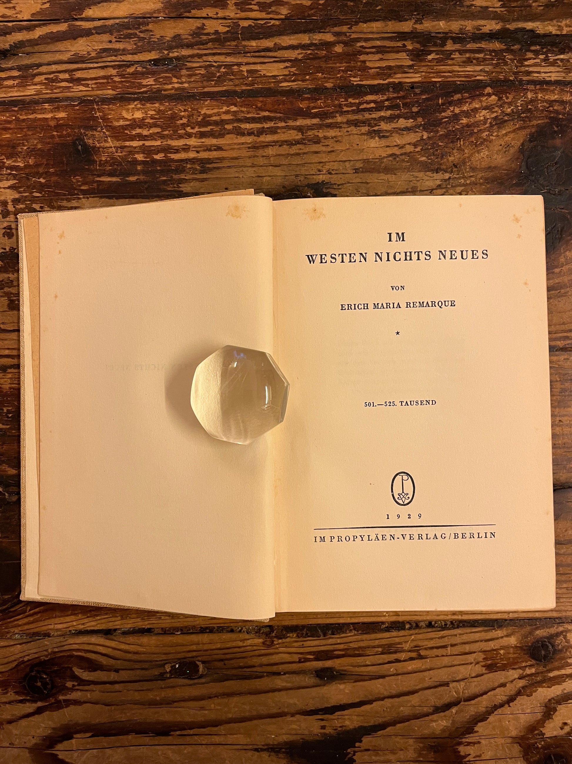 photo of the title page of the book" im westen nichts neues" on a wooden background