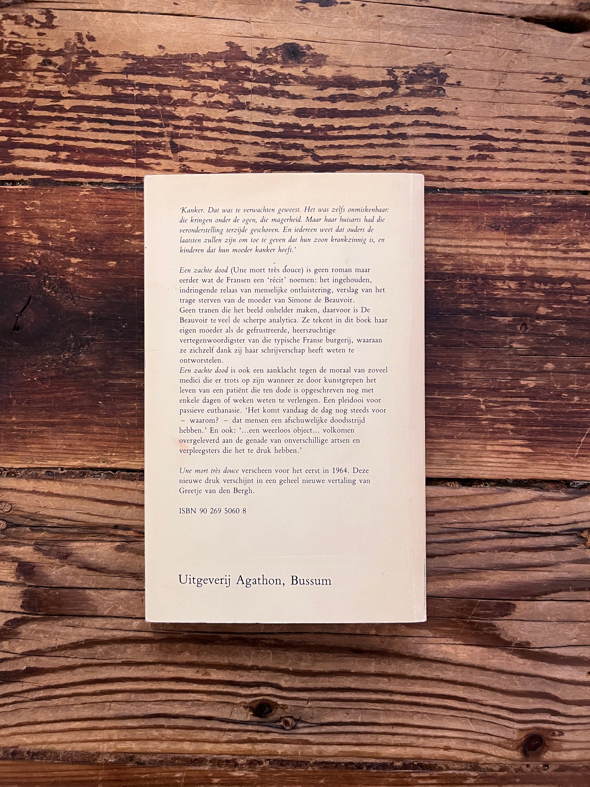 foto van de backcover van het boek "een zachte dood" op houten achtergrond