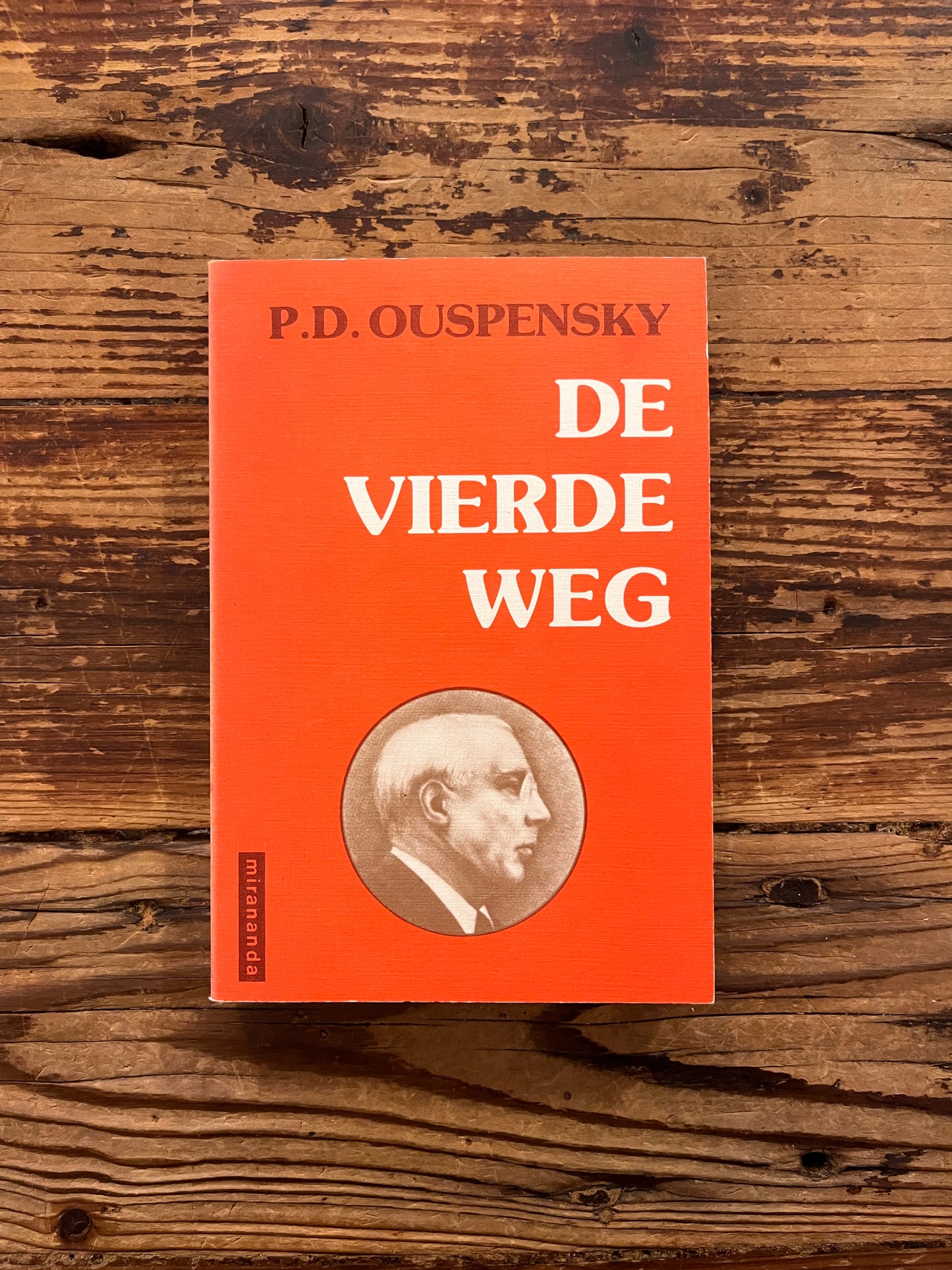 Voorkant van boek met de titel 'de vierde weg door P.D. Ouspensky op een houten achtergrond 
