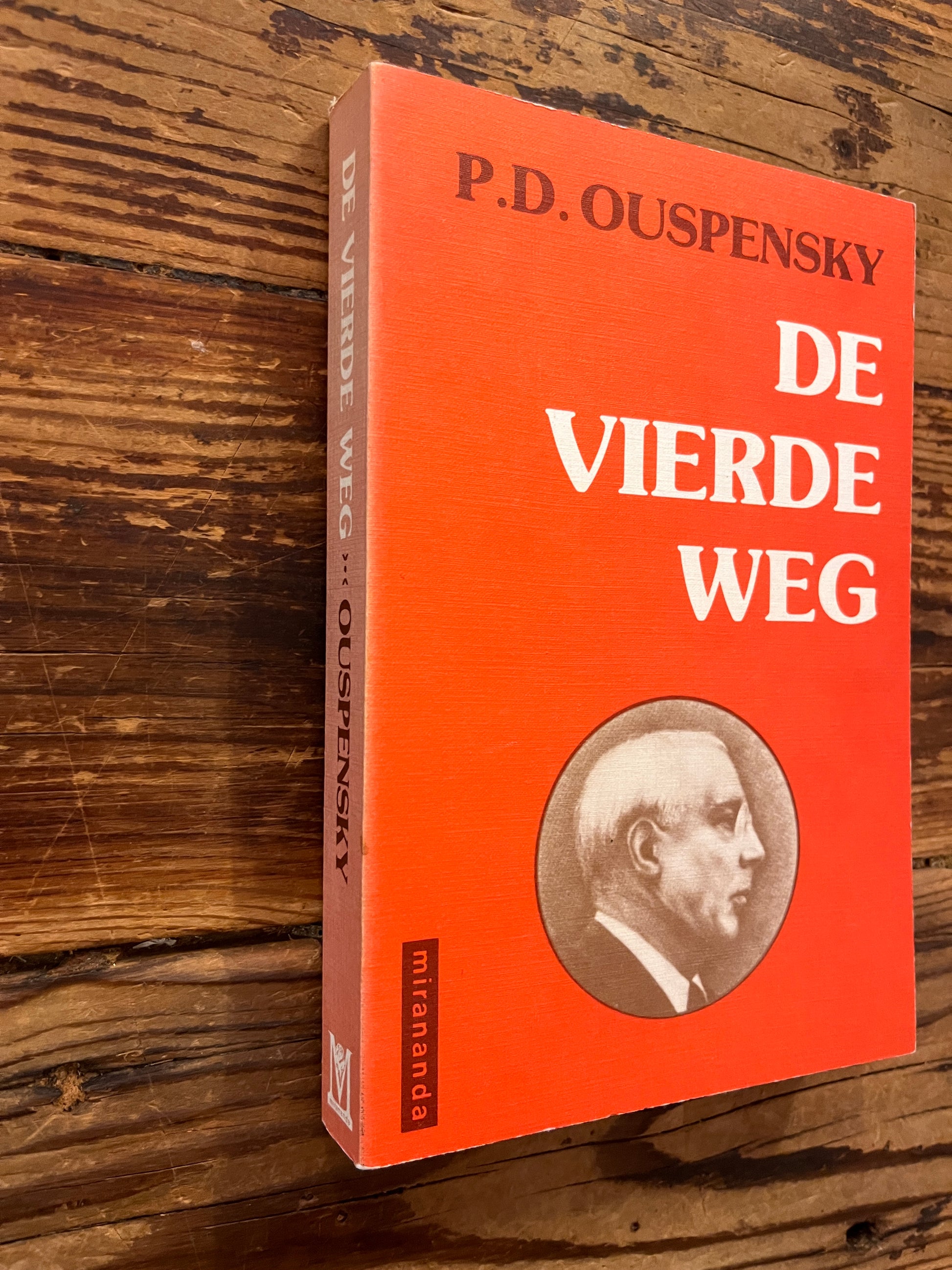 Voorkant  en rug van boek met de titel 'de vierde weg door P.D. Ouspensky op een houten achtergrond 