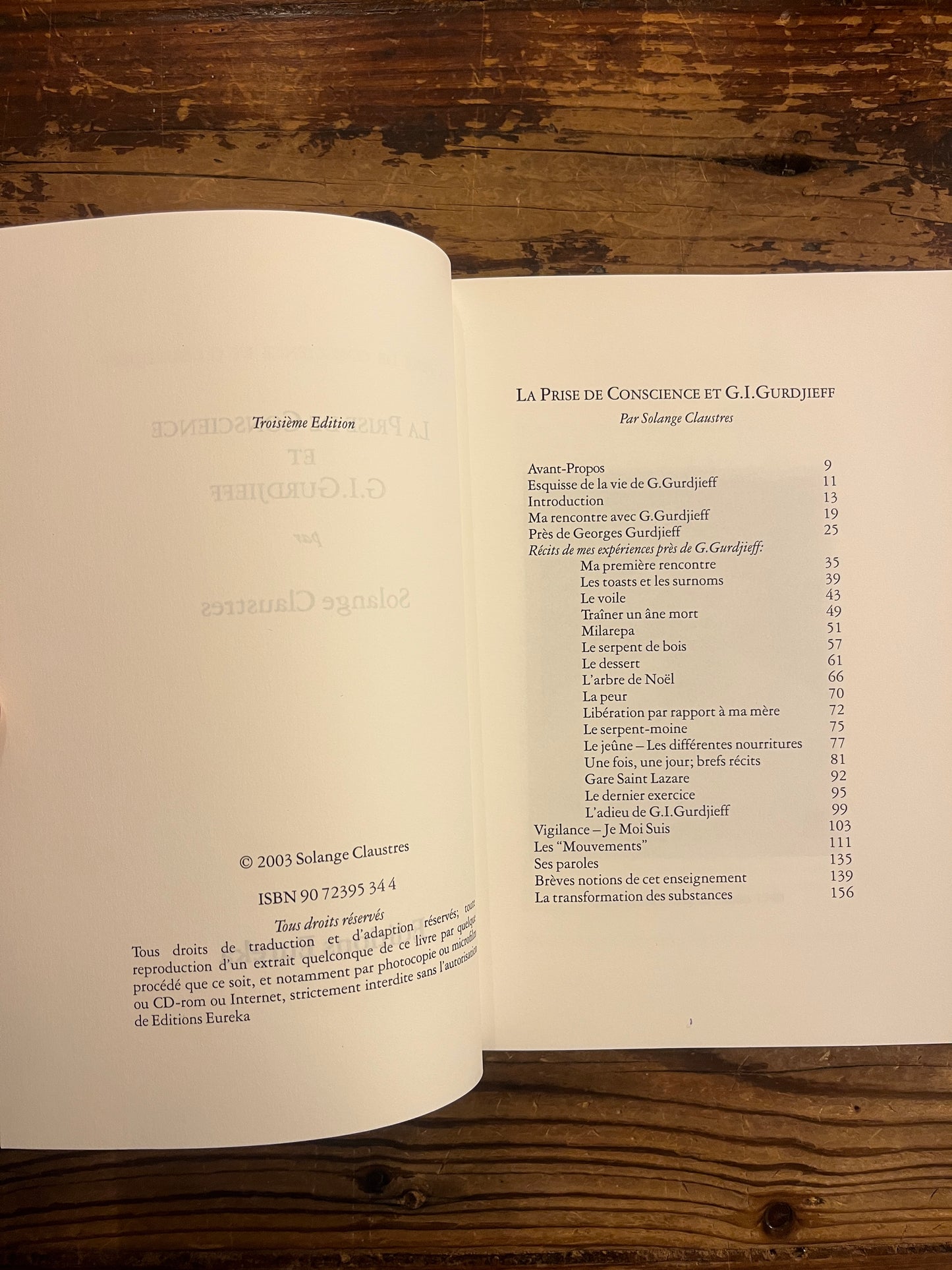 Livre 'la prise de conscience et G.I. Gurdjieff' par Solange Claustres sur un fond en bois