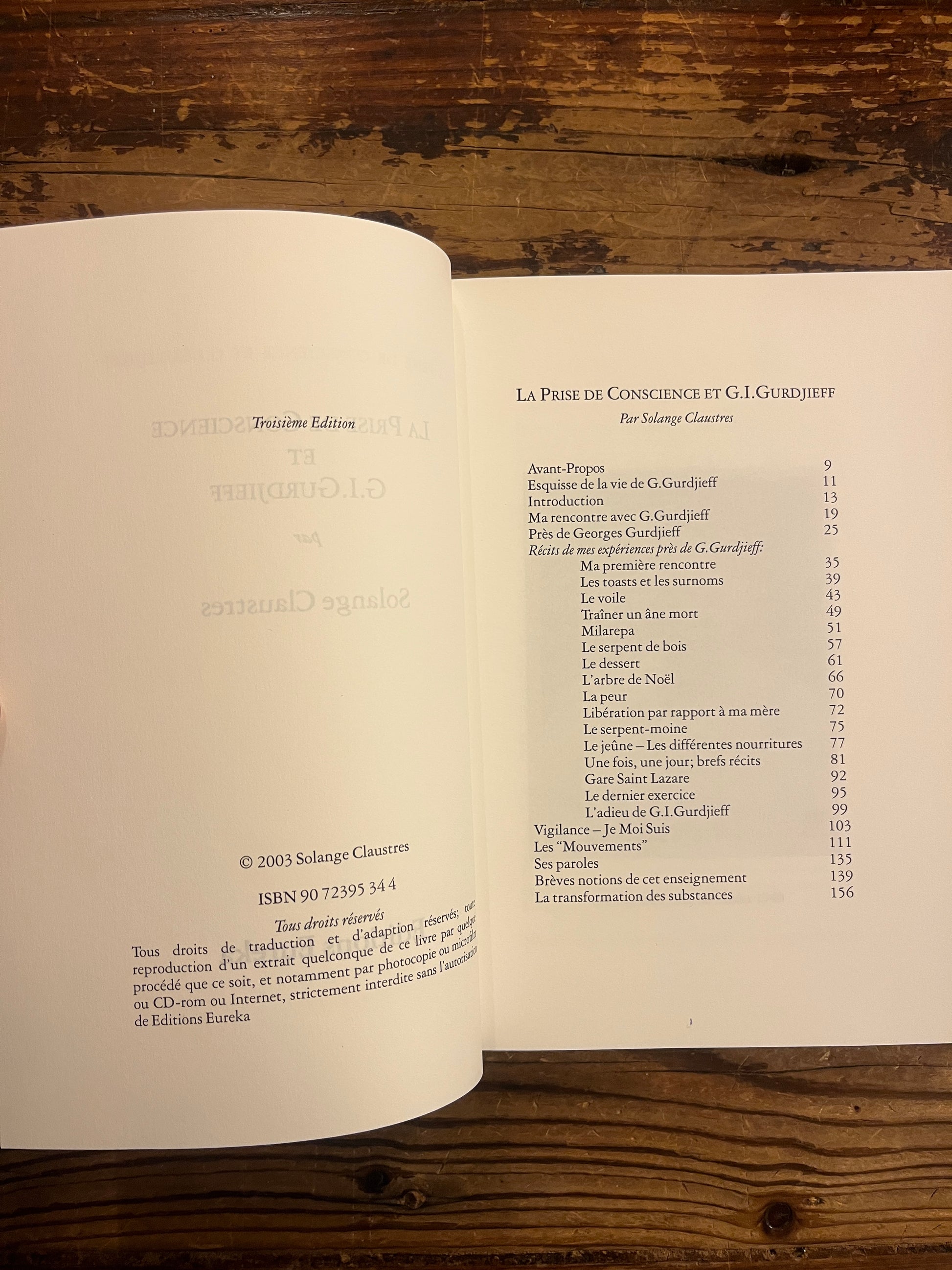 Livre 'la prise de conscience et G.I. Gurdjieff' par Solange Claustres sur un fond en bois