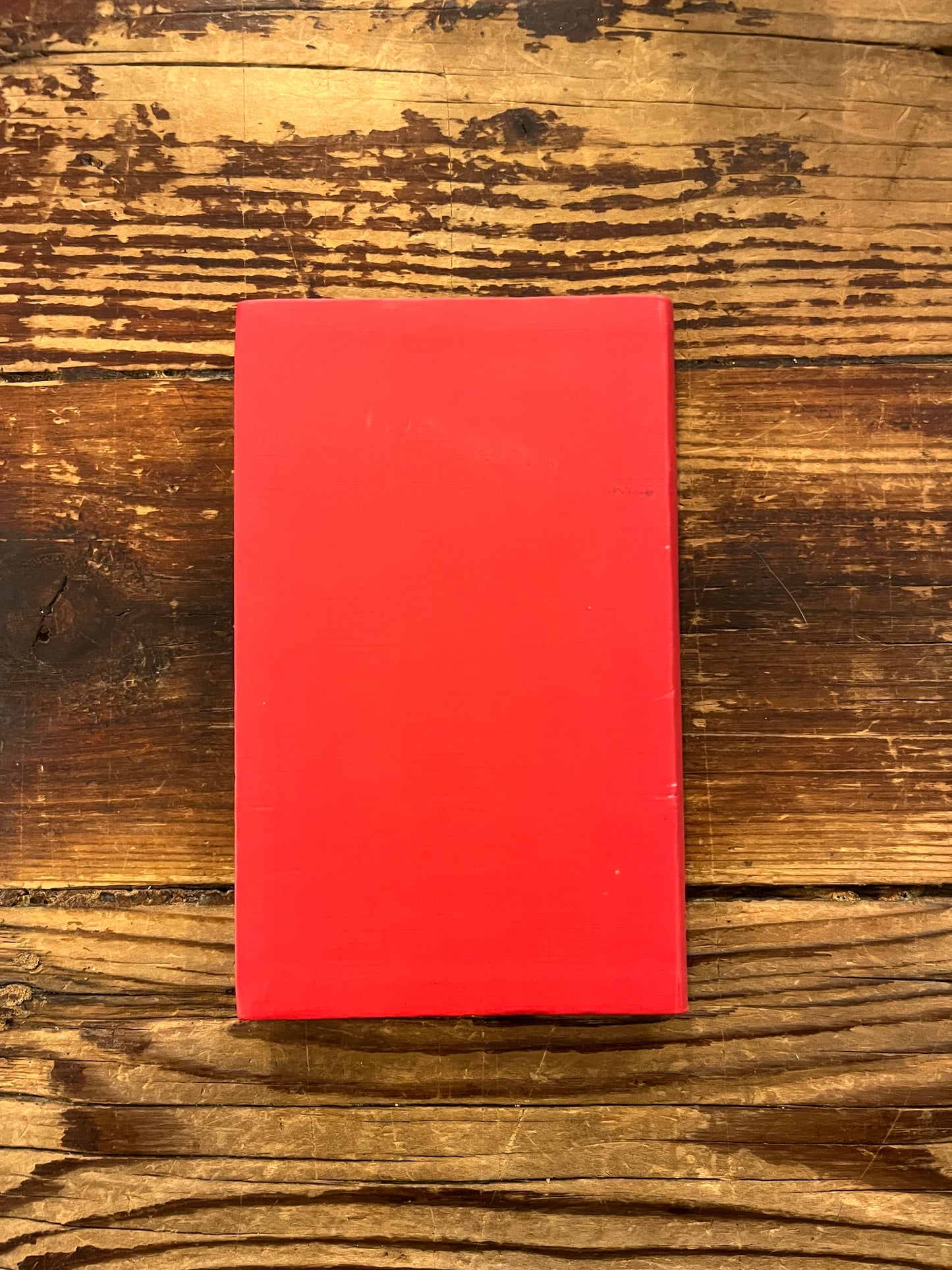 Achterkant Boek met de titel 'de kleine I Tjing' op een houten achtergrond 