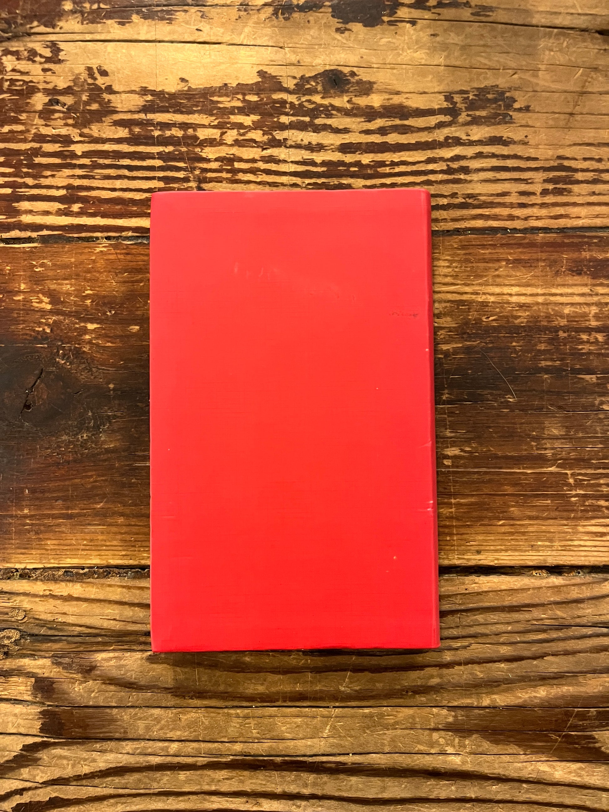 Achterkant Boek met de titel 'de kleine I Tjing' op een houten achtergrond 