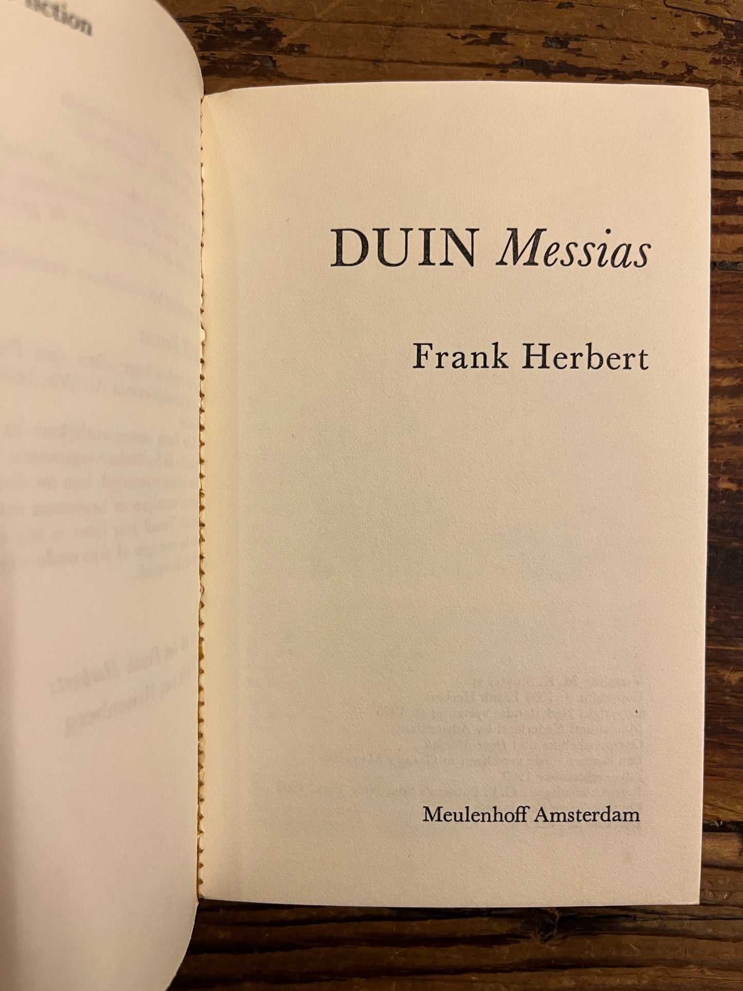 Open boek op titel pagina, boek met de titel 'Duin Messias' door Frank Herbert op een houten achtergrond