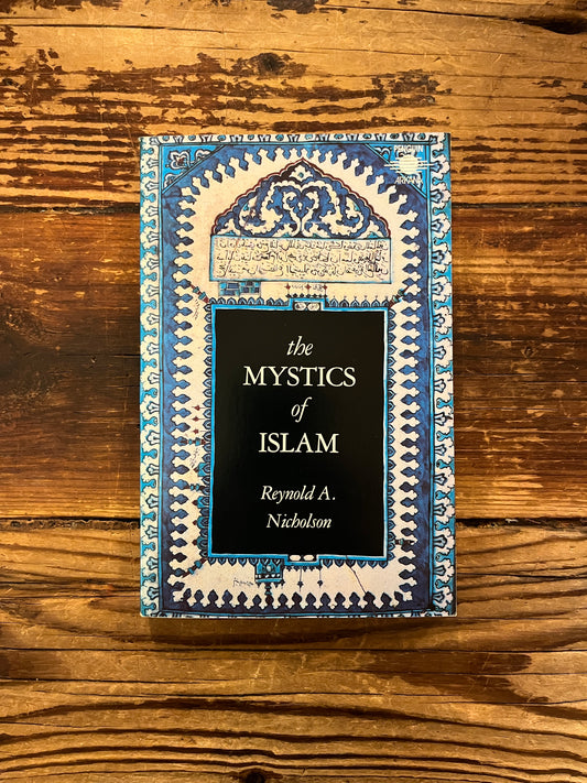 Front cover of book titled 'The Mystics of Islam' by Reynold Nicholson on a wooden surface