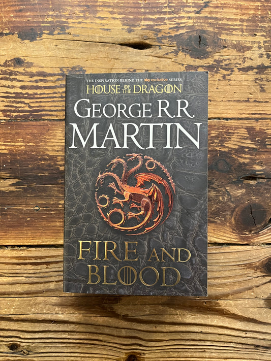 Front cover of book titled 'Fire and Blood' by George R.R. Martin on a wooden surface