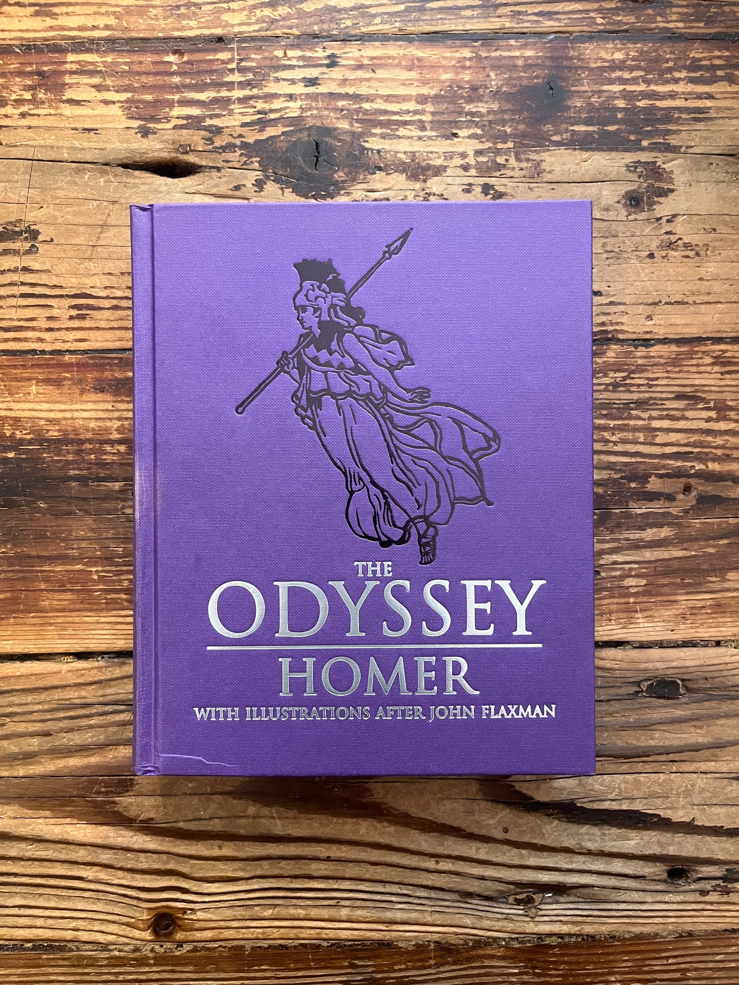 Front cover of book titled 'The Odyssey' by Homer and translated by A. Pope on a wooden surface