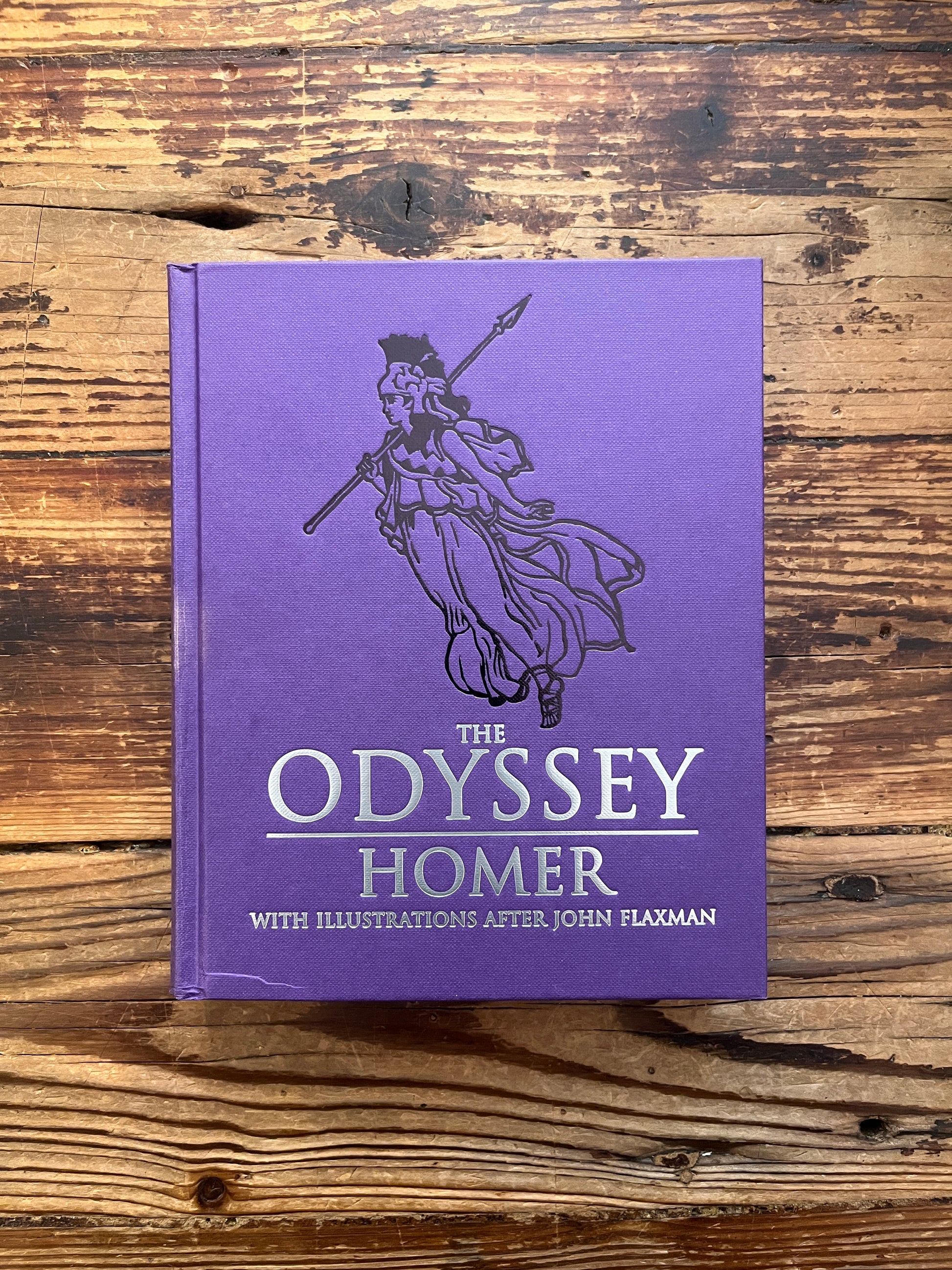 Front cover of book titled 'The Odyssey' by Homer and translated by A. Pope on a wooden surface