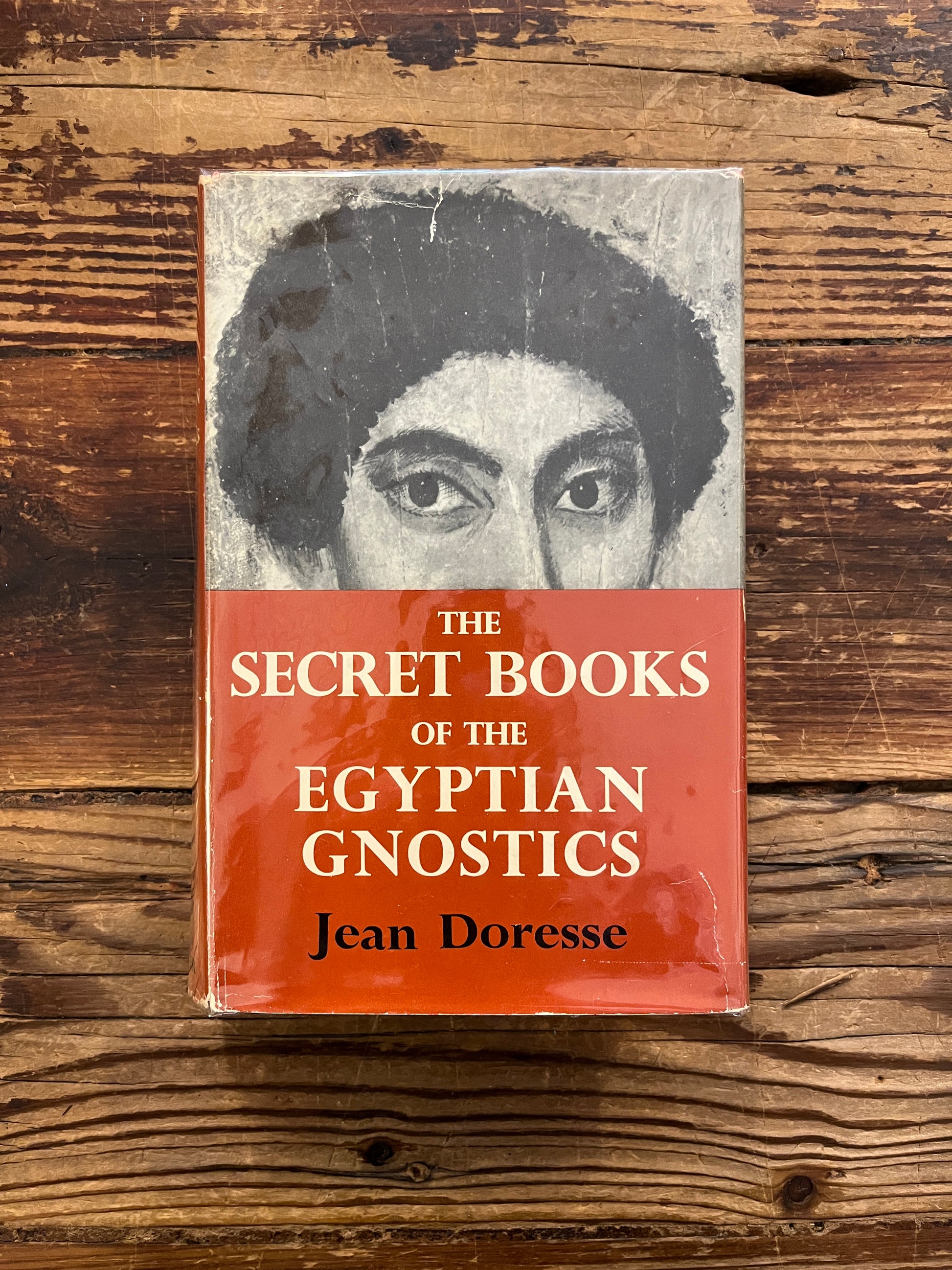 Front cover of book titled 'The Secret Books of the Egyptian Gnostics' by Jean Doresse on a wooden surface