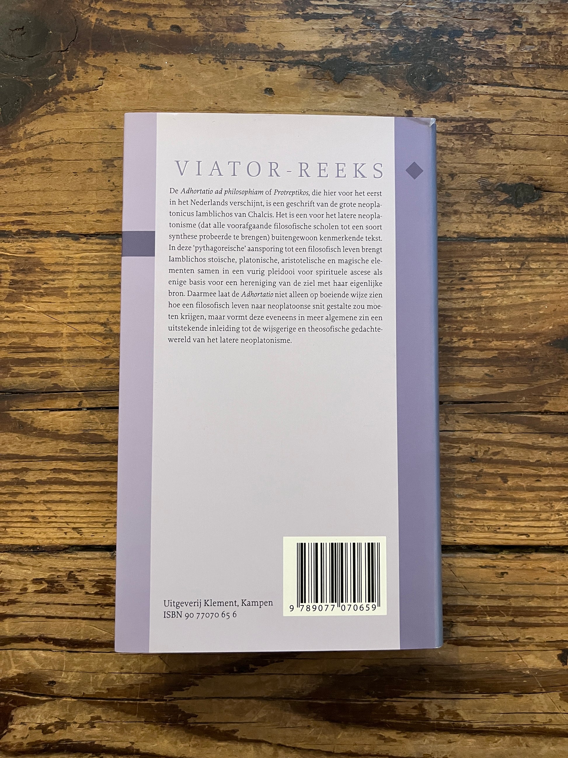 foto van de backcover van het boek "aansporing tot filosofie" op houten achtergrond