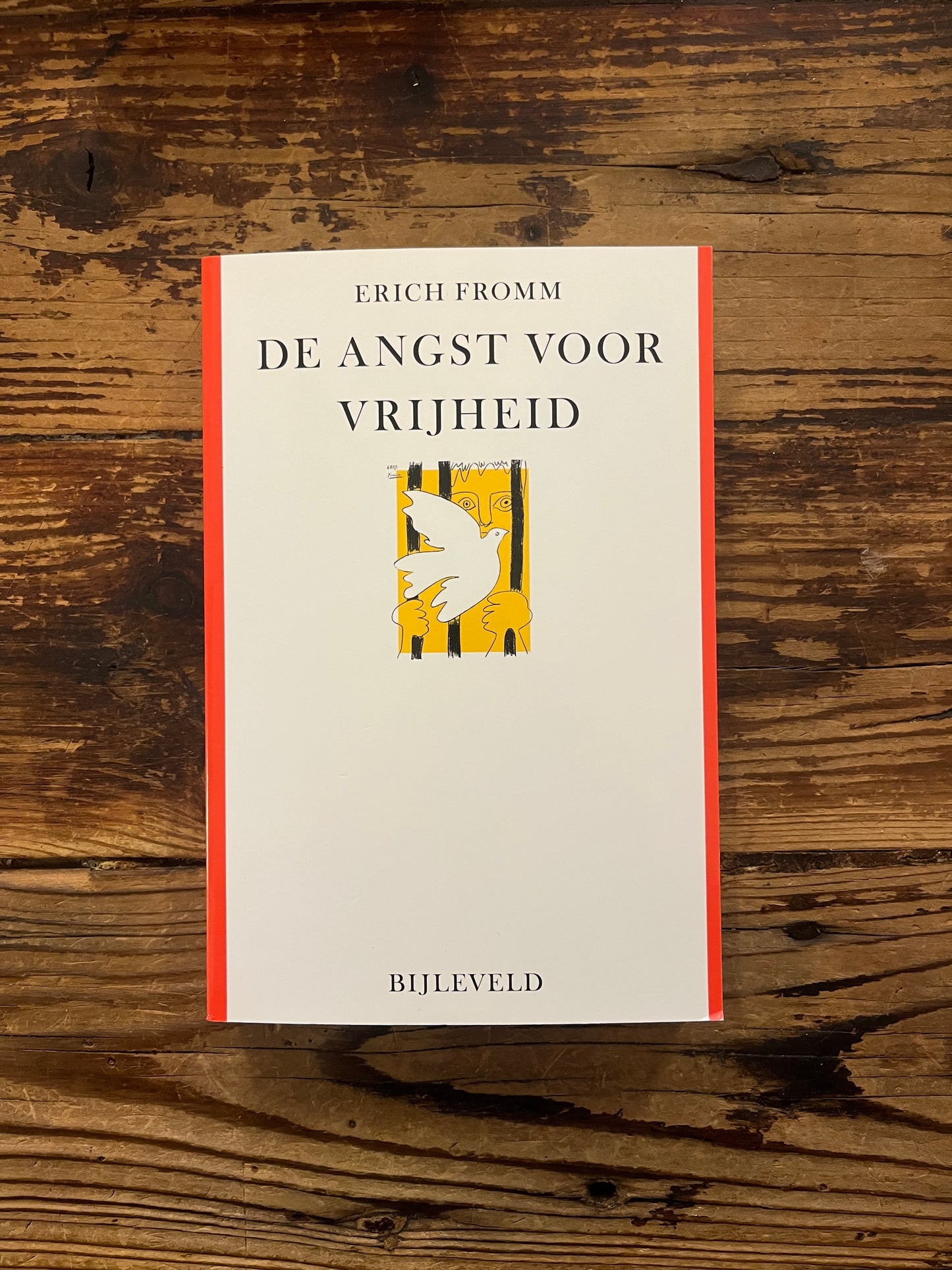 Boek met de titel 'De Angst voor Vrijheid' door Erich Fromm op een houten achtergrond